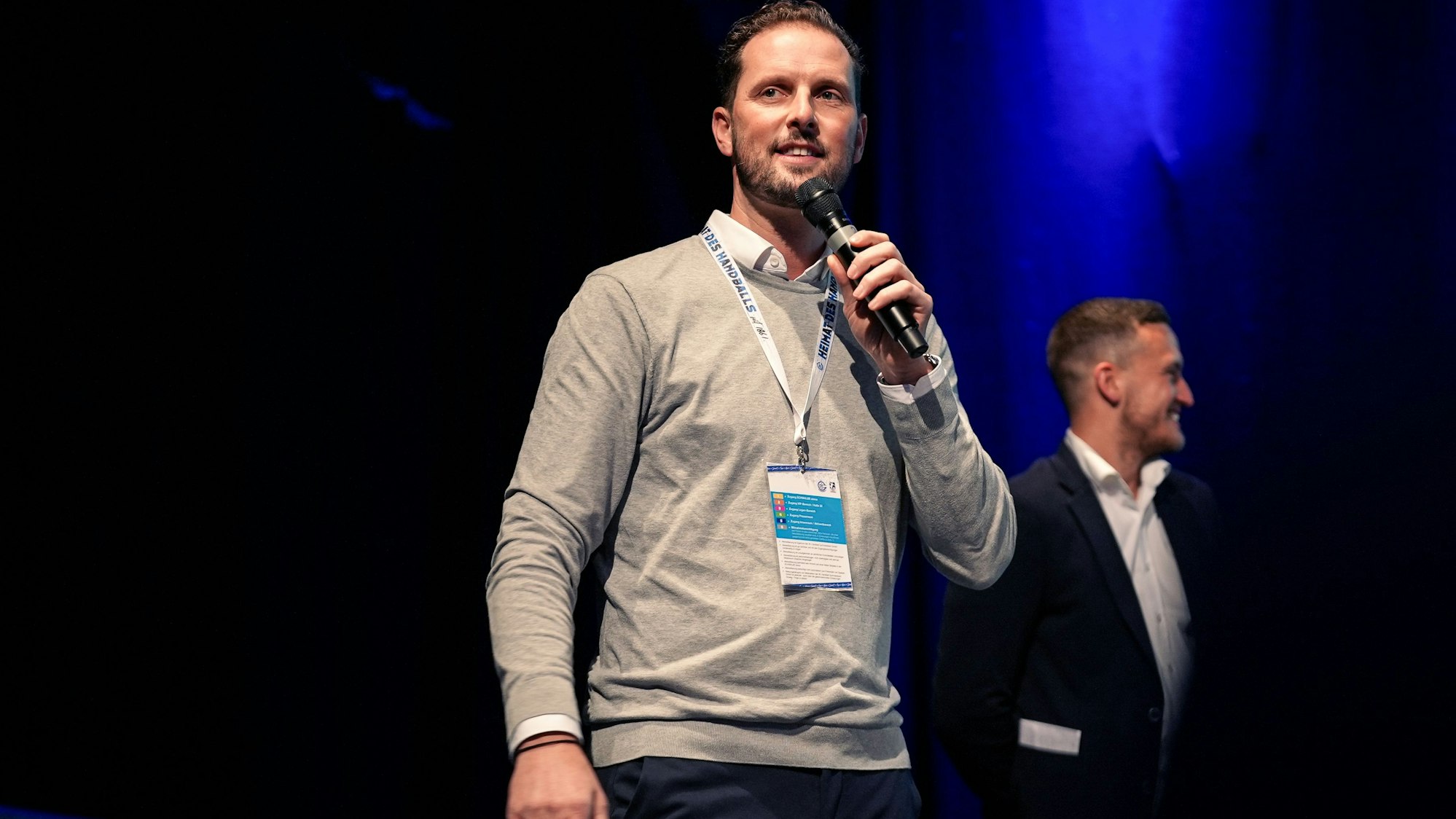 Christoph Schindler, Geschäftsführer VfL Gummersbach, spricht auf der Bühne in ein Mikrofon.