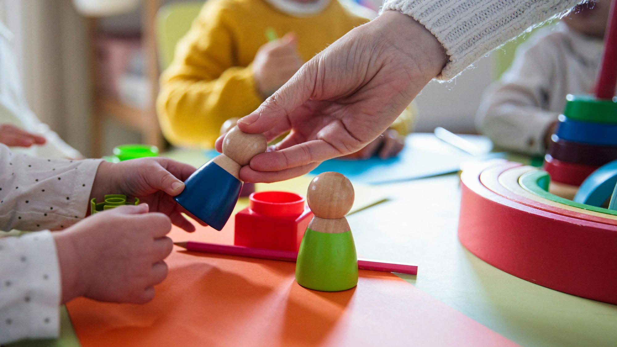 Kinder spielen mit Holzfiguren im Kindergarten
Getty Images / Lourdes  Balduque