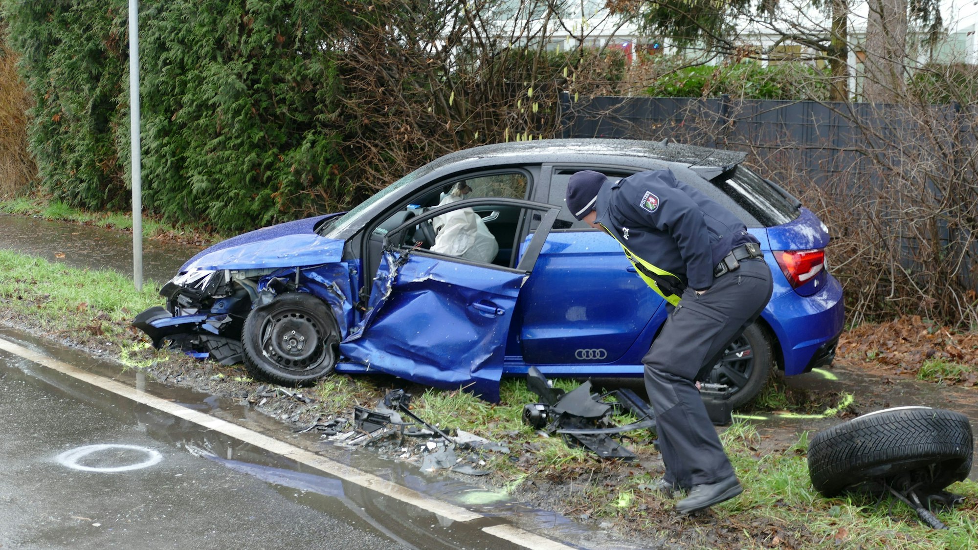 Ein zerstörtes Auto steht am Straßenrand.