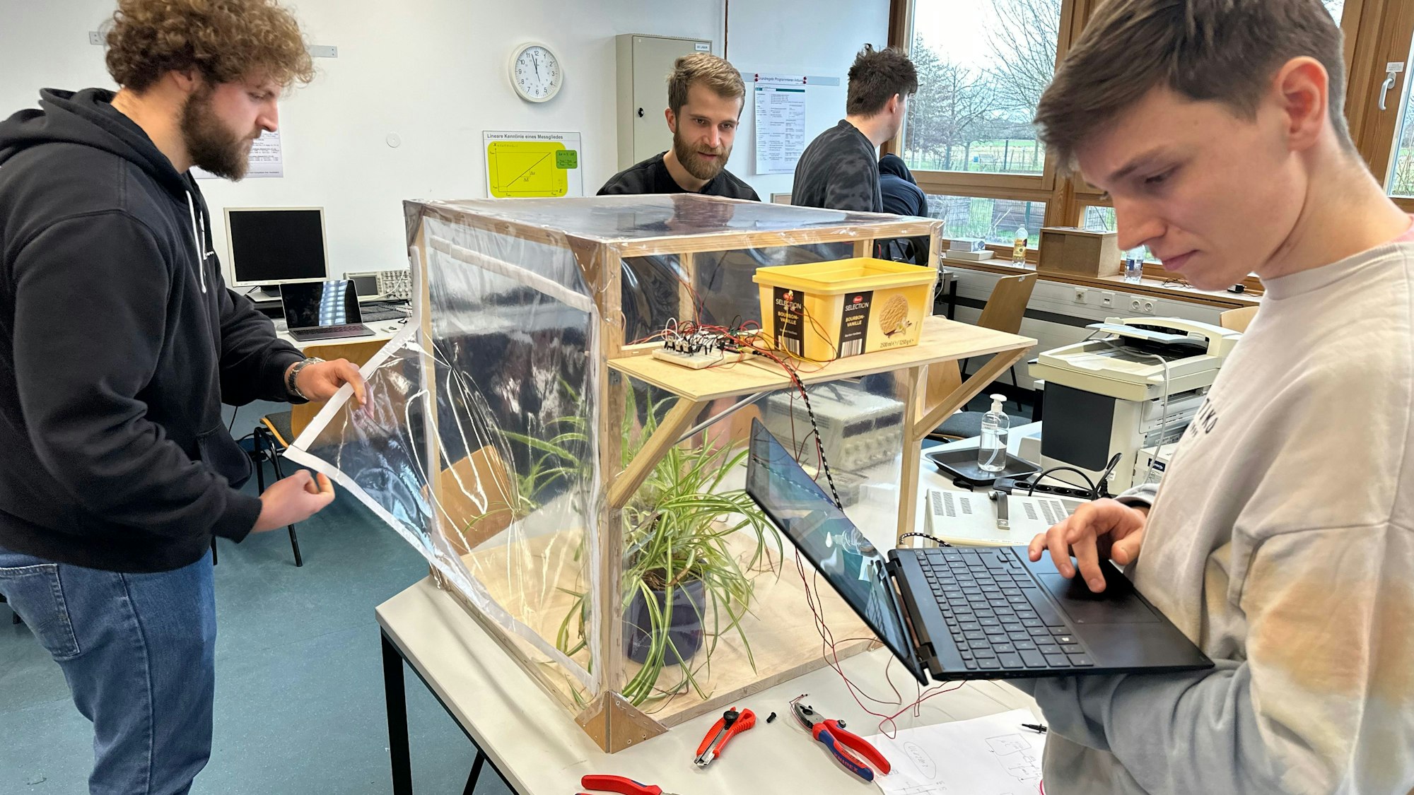 Projekttag an der Hochschule Bonn-Rhein-Sieg, die Studenten Philipp Weber, Aaron Zinken und Fabian Liesenfeld präsentieren ein Gewächshaus, das die Pflanzen im Inneren selber versorgt.