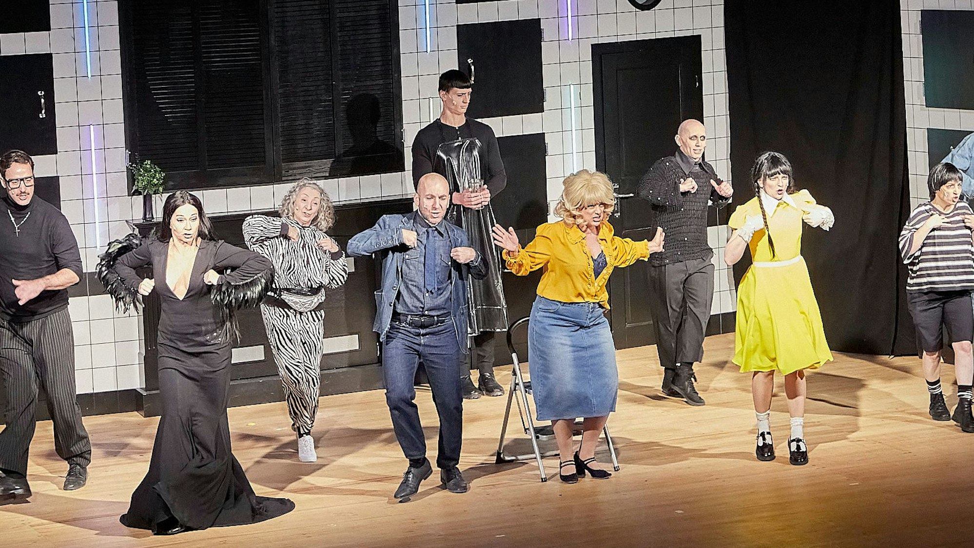 Auf der Bühne stehen die düster verkleideten Schaupieler und tanzen.