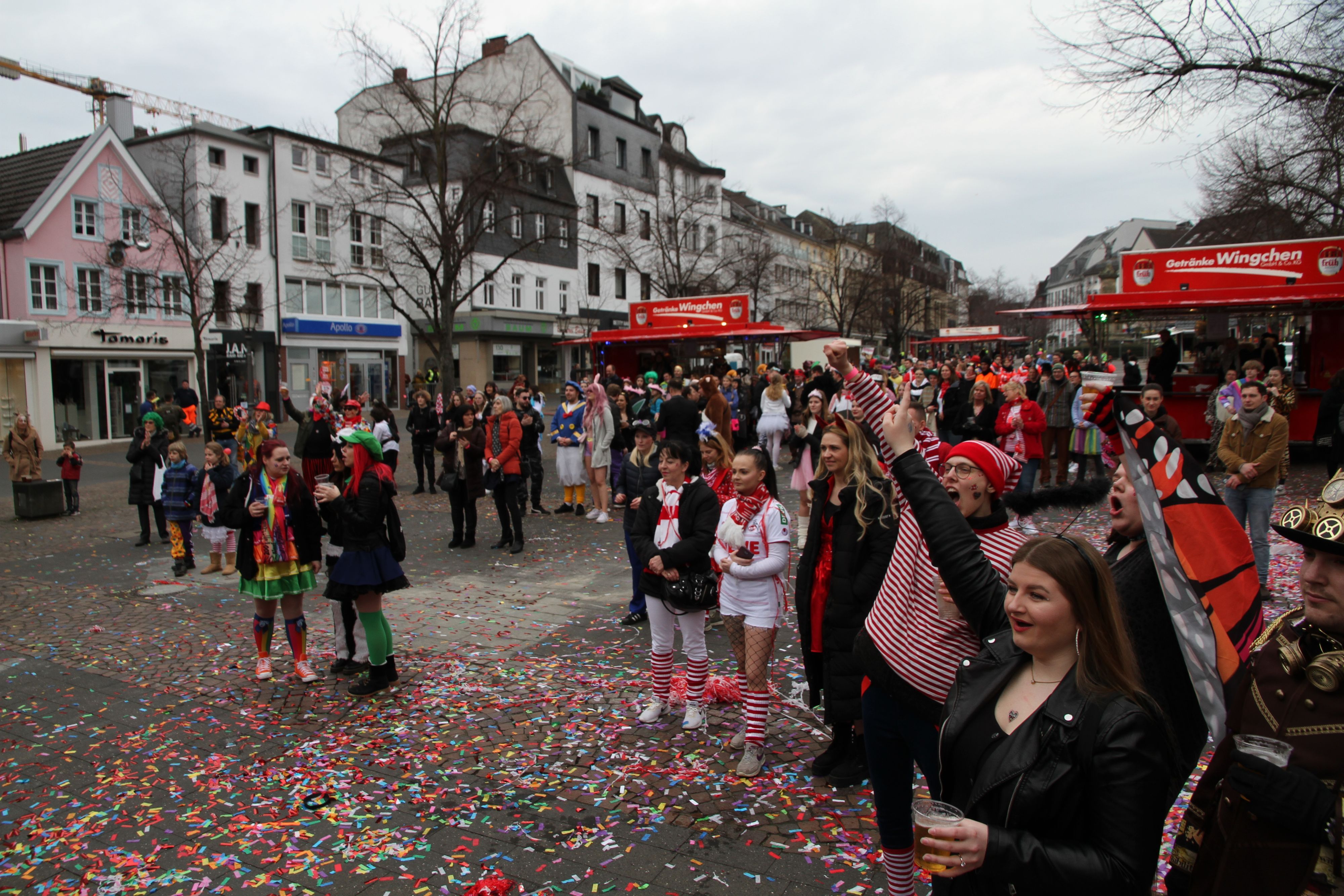 Kostümierte Jecke feiern auf einem Marktplatz