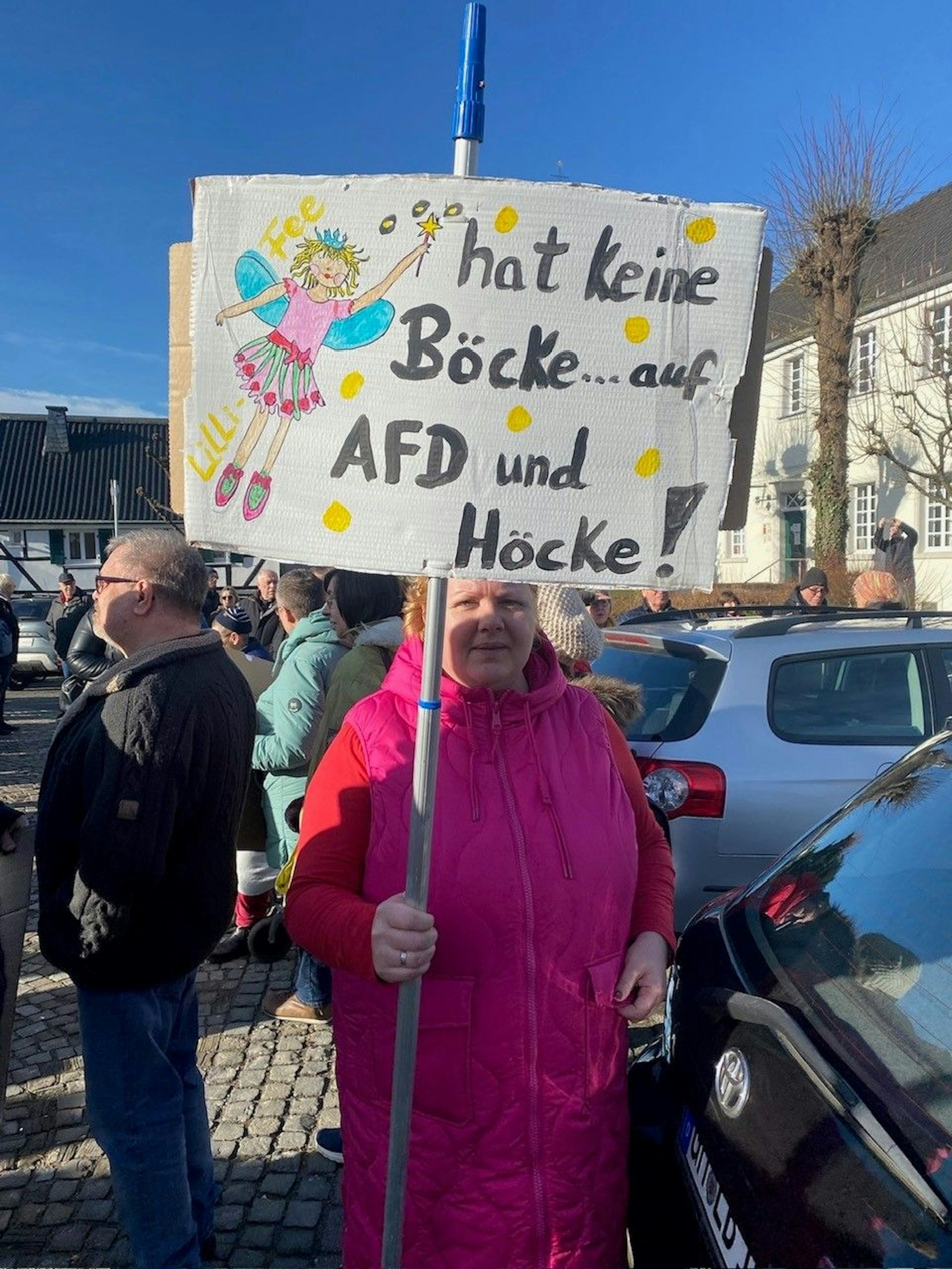 Auch in Lindlar waren es mehrere Hundert Menschen, die sich nach einem Aufruf des Runden Tischs für Frieden und Gerechtigkeit, SPD und Grünen und den Kreis-Linken auf dem Marktplatz trafen. Das Motto hier lautete „Lindlar gegen Rechts“. Eine Frau hält ein Plakat mit einer Botschaft in Händen.