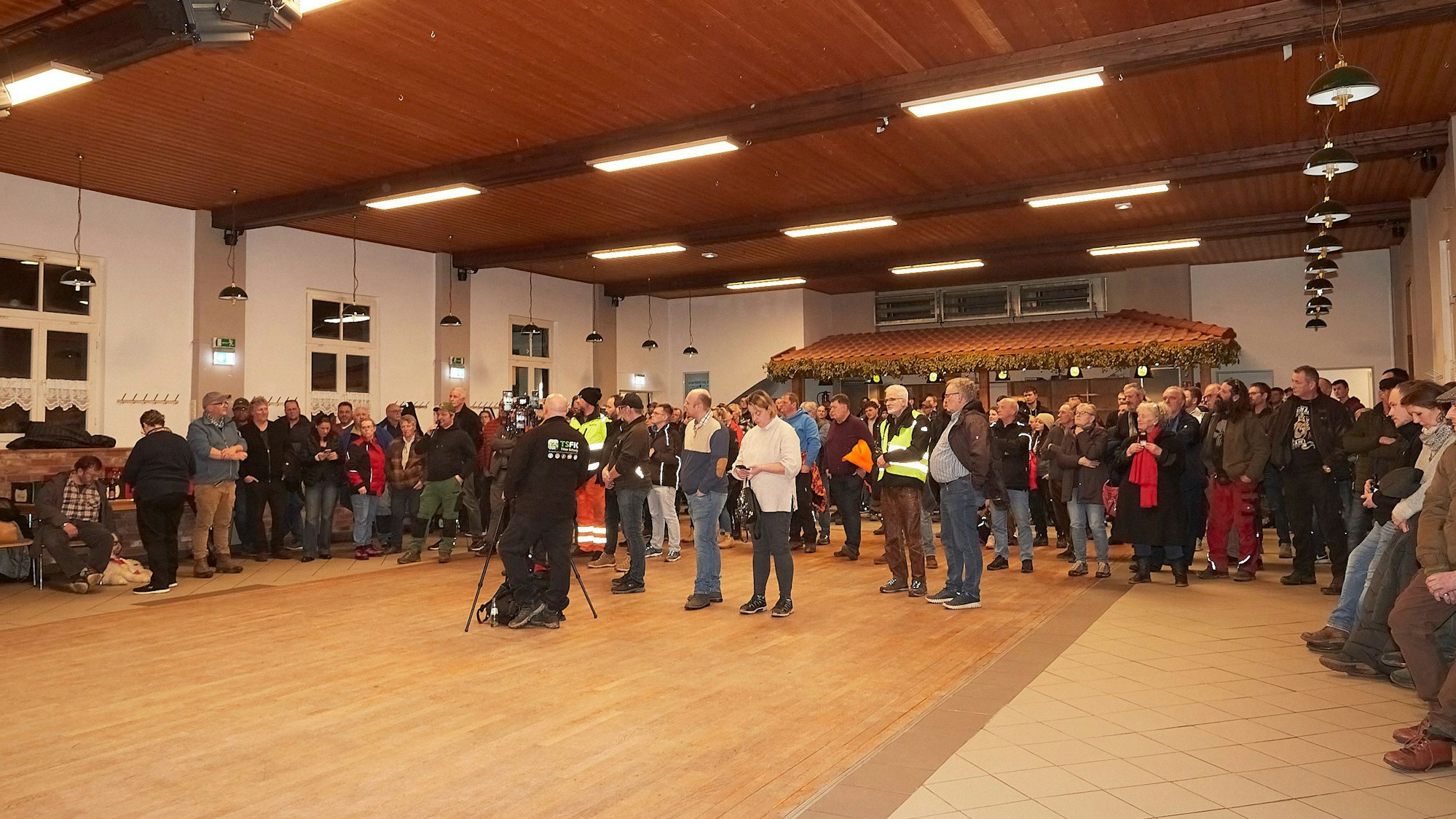 Menschen stehen im Tondorfer Dorfsaal.