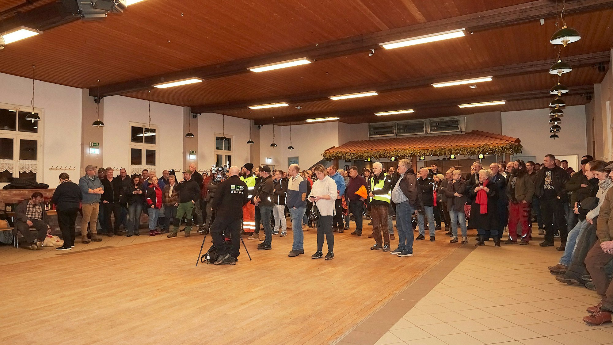 Menschen stehen im Tondorfer Dorfsaal.