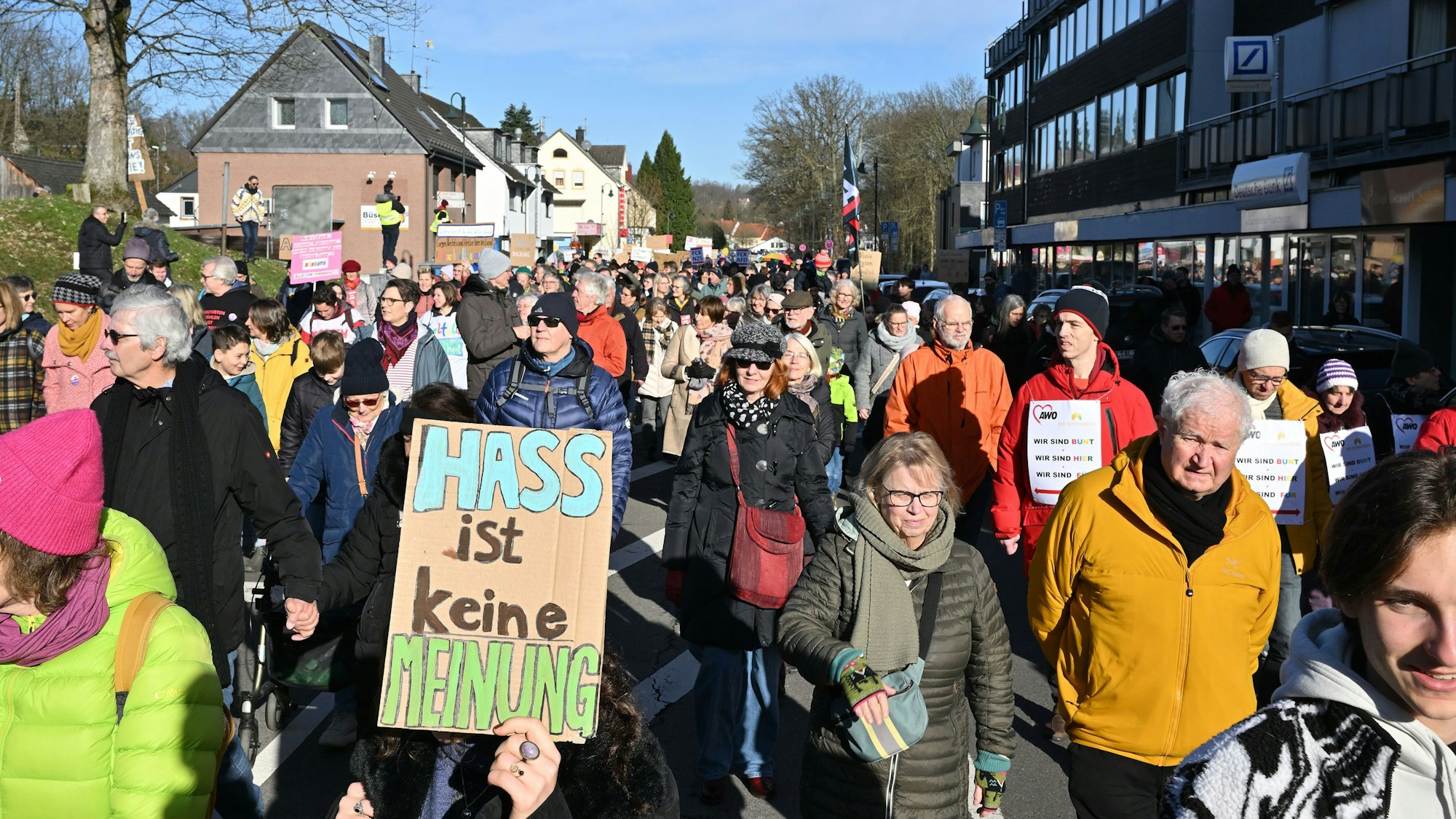 „Hass ist keine Meinung“ steht auf einem Schild von Demonstrierenden, die auf der Hauptstraße ziehen.
