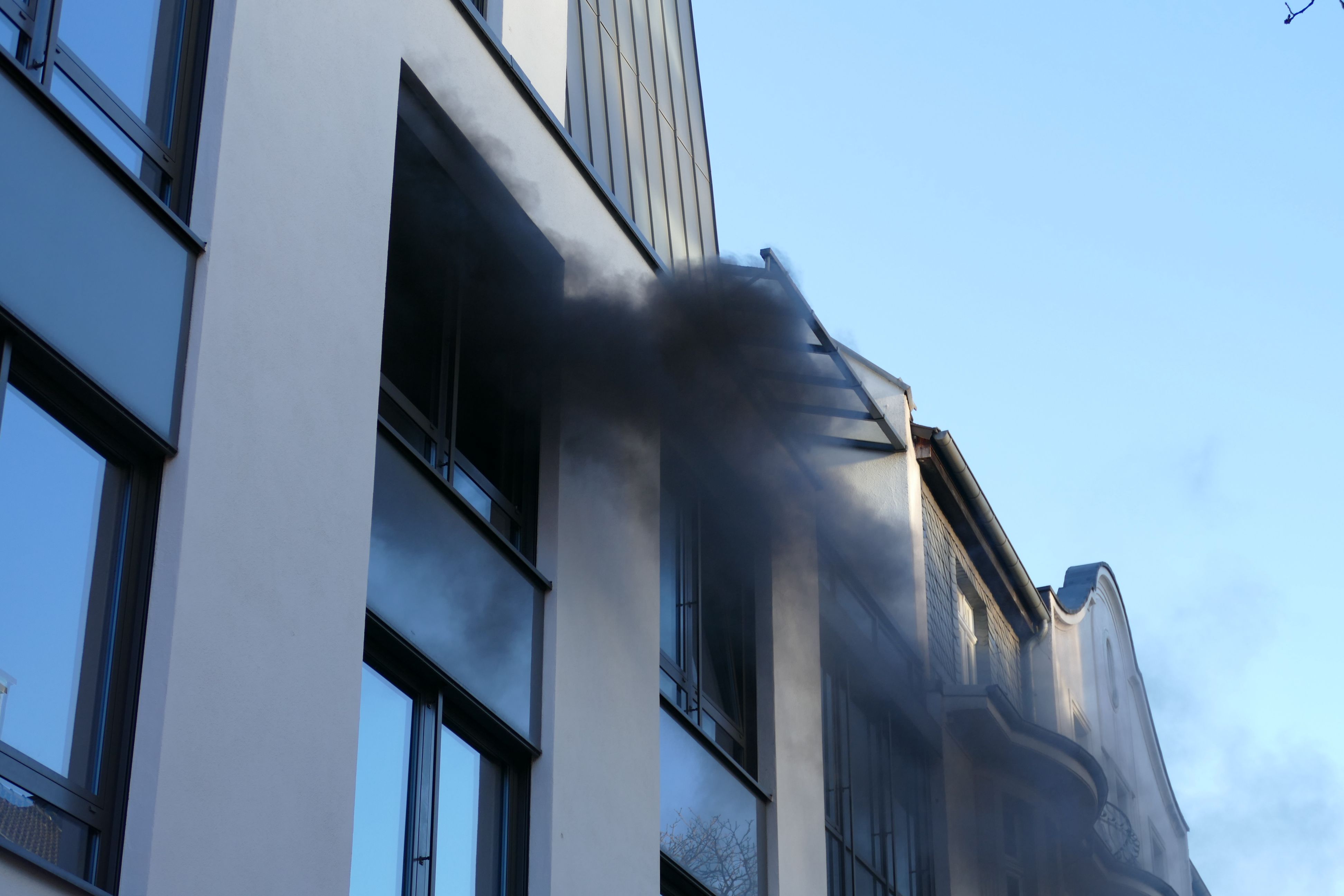 Rauch dringt aus einem Fenster.
