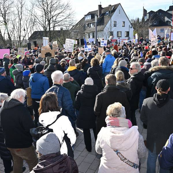 Menschen stehen mit Plakaten dicht gedrängt auf dem Rösrather Sülztalplatz.