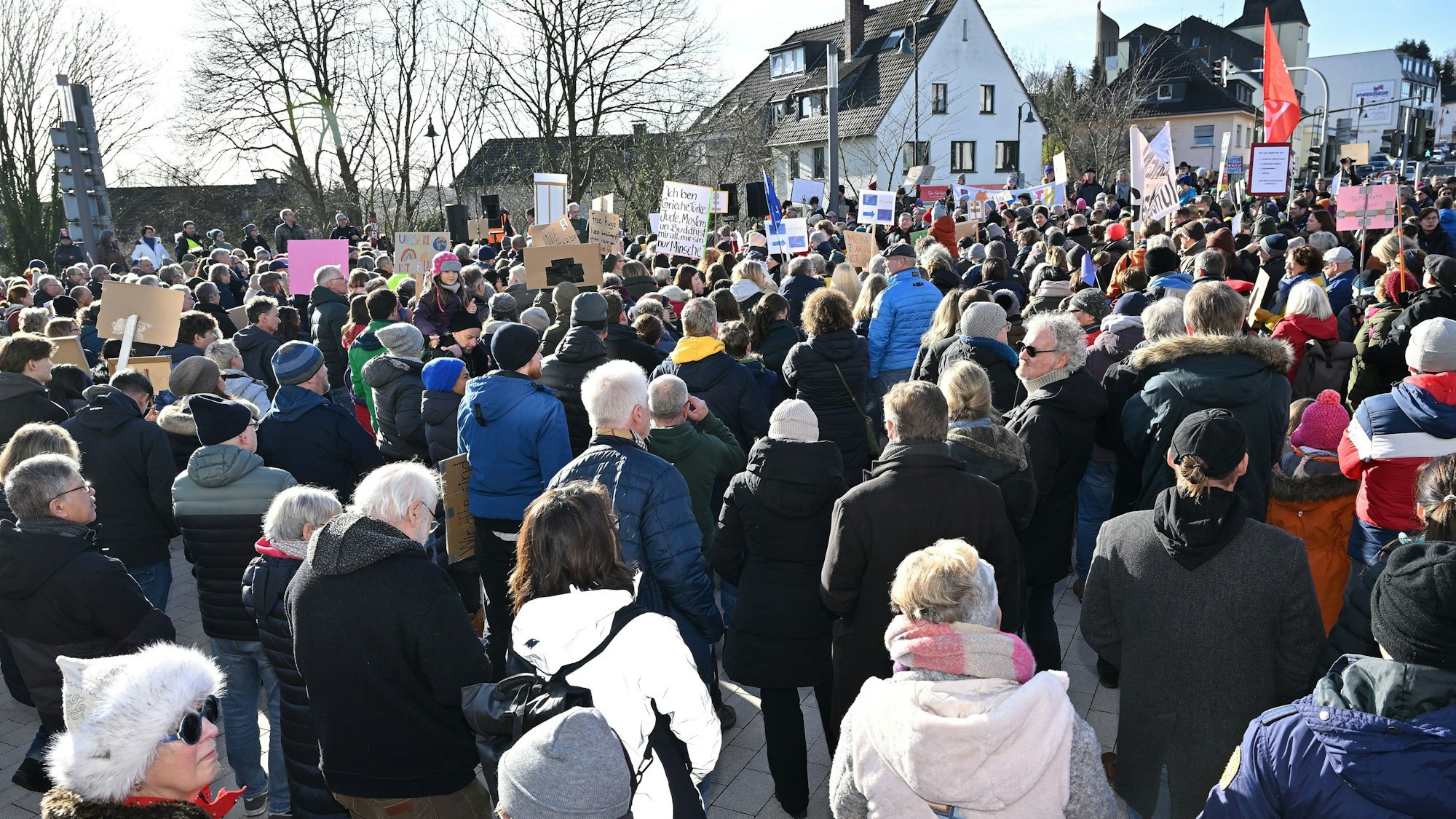 Menschen stehen mit Plakaten dicht gedrängt auf dem Rösrather Sülztalplatz.