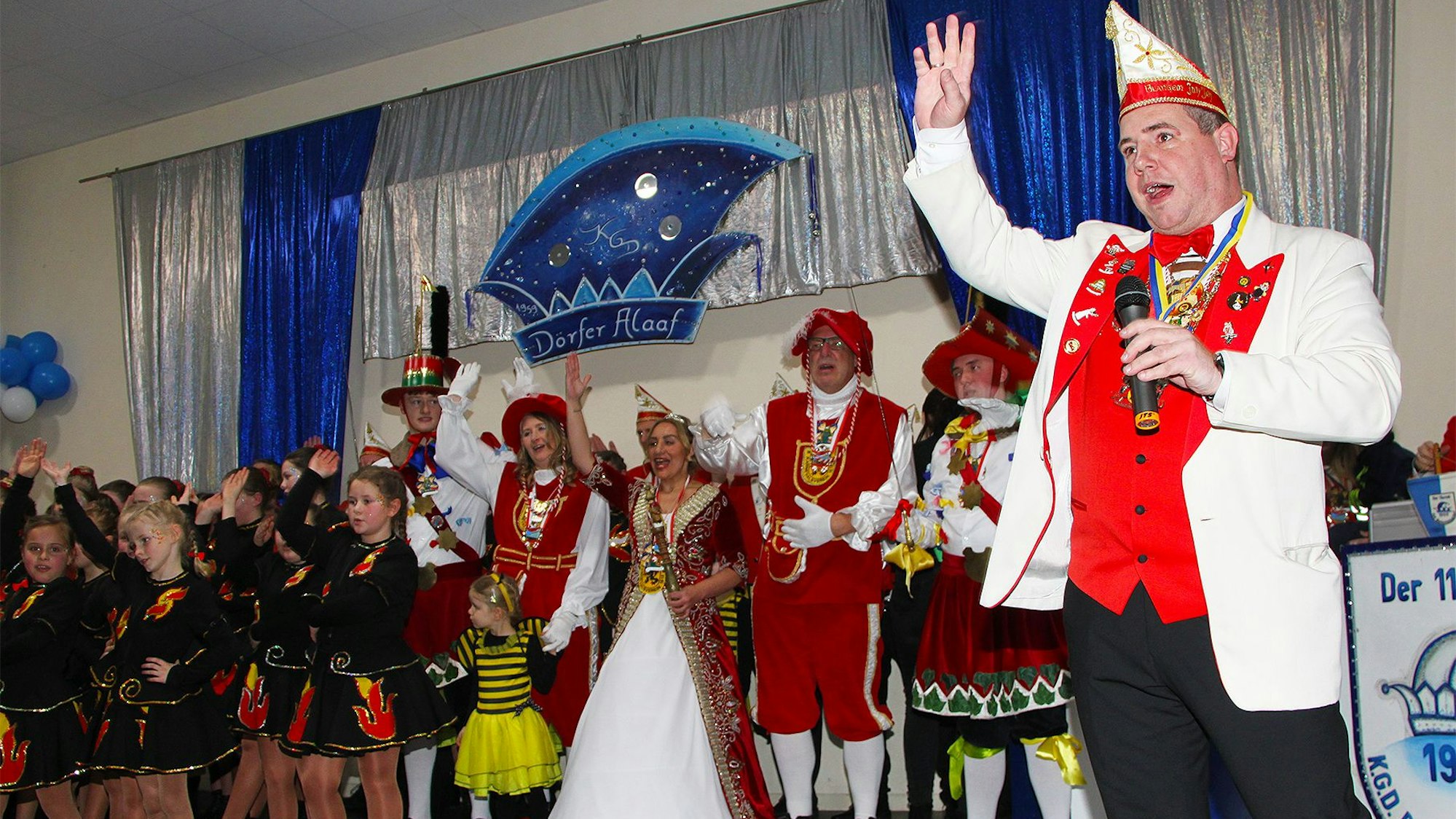 Kostümierte Karnevalisten stehen auf einer Bühne.