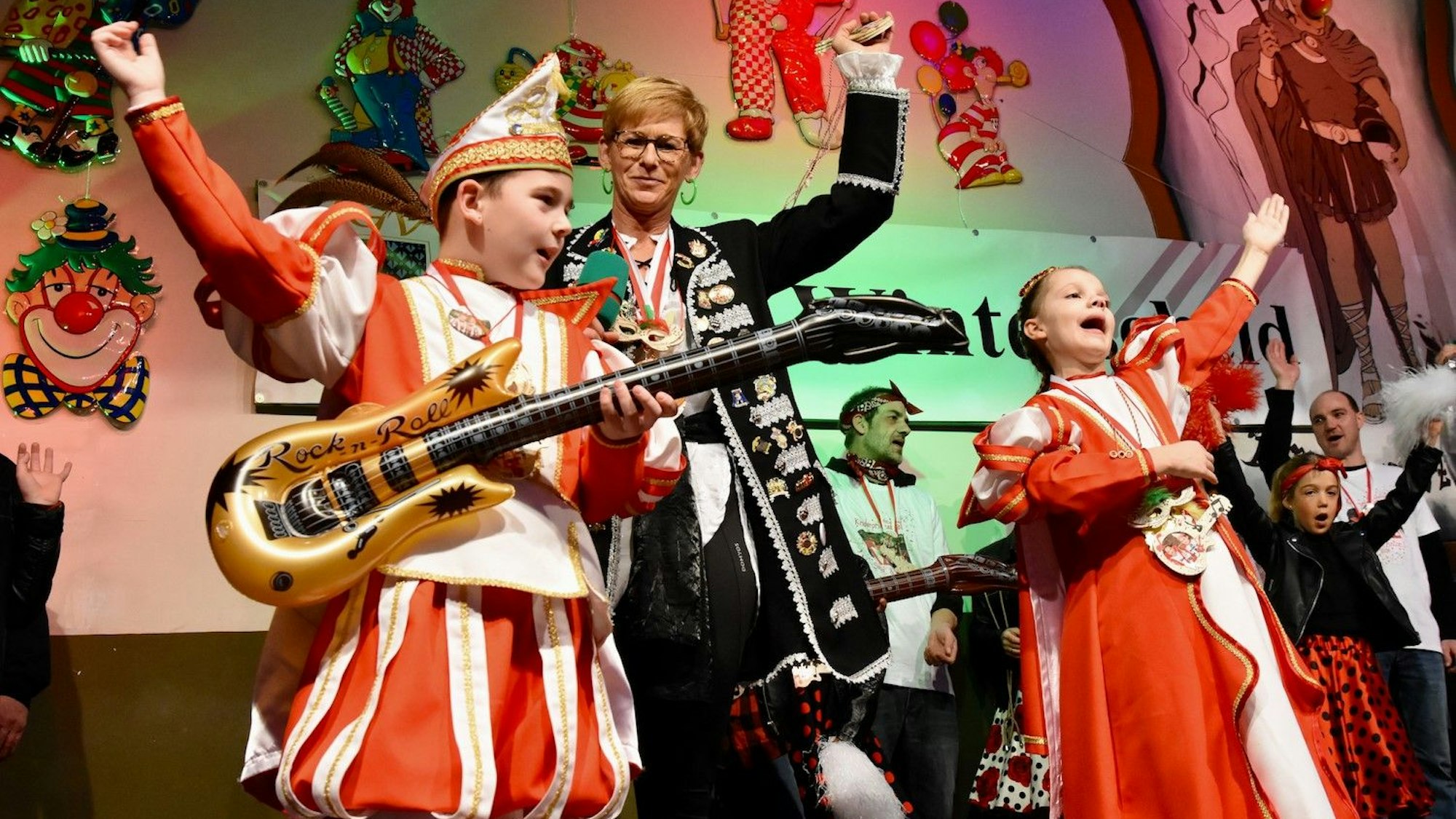 Ein Karnevalskinderprinzenpaar, in der Mitte eine erwachsene Frau in einer Piratenjacke.