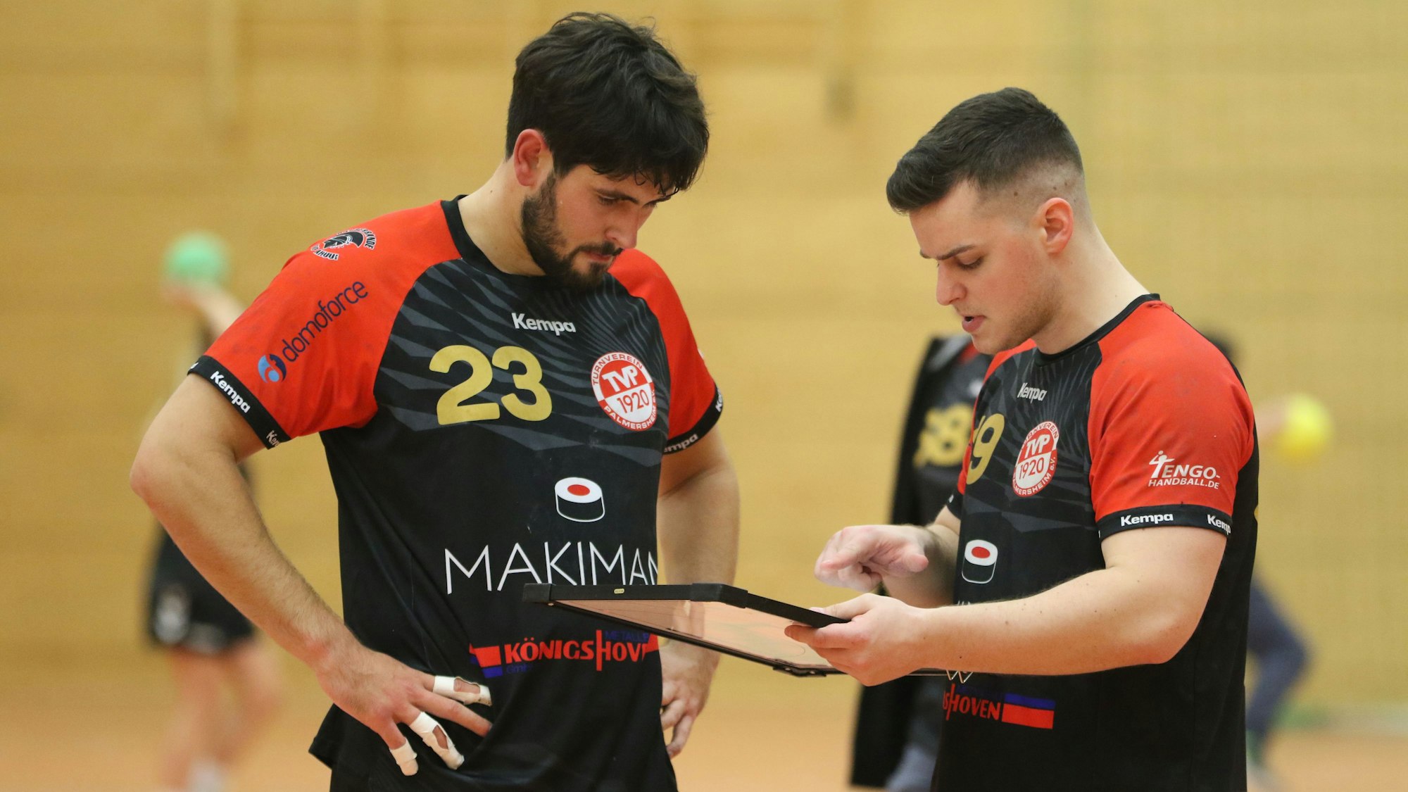 Das Bild zeigt die beiden Palmersheimer Spieler im Gespräch. Mayer hält eine Taktiktafel in der Hand.