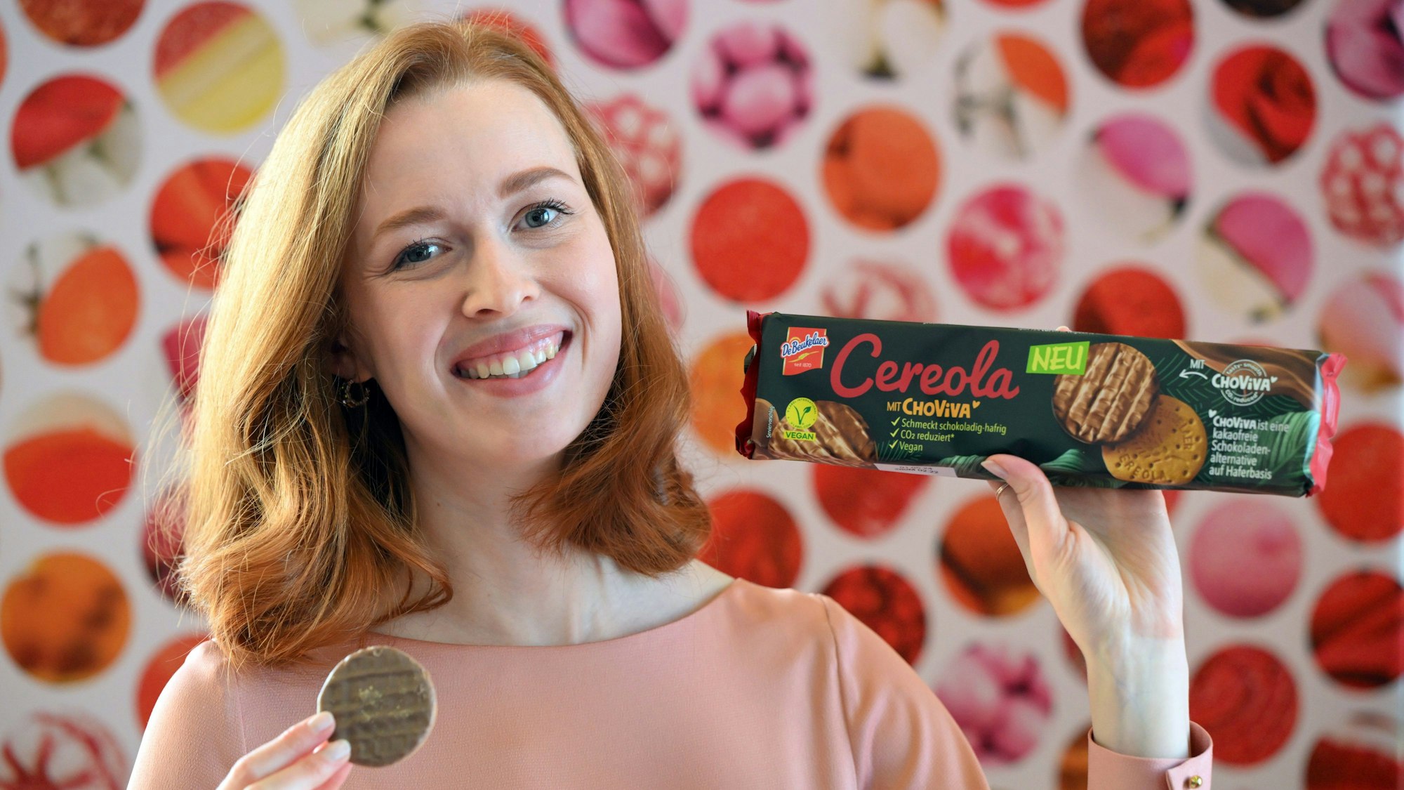 Model Christin präsentiert auf der Internationalen Süßwarenmesse ChoViva-Kekse von DeBeukeler.