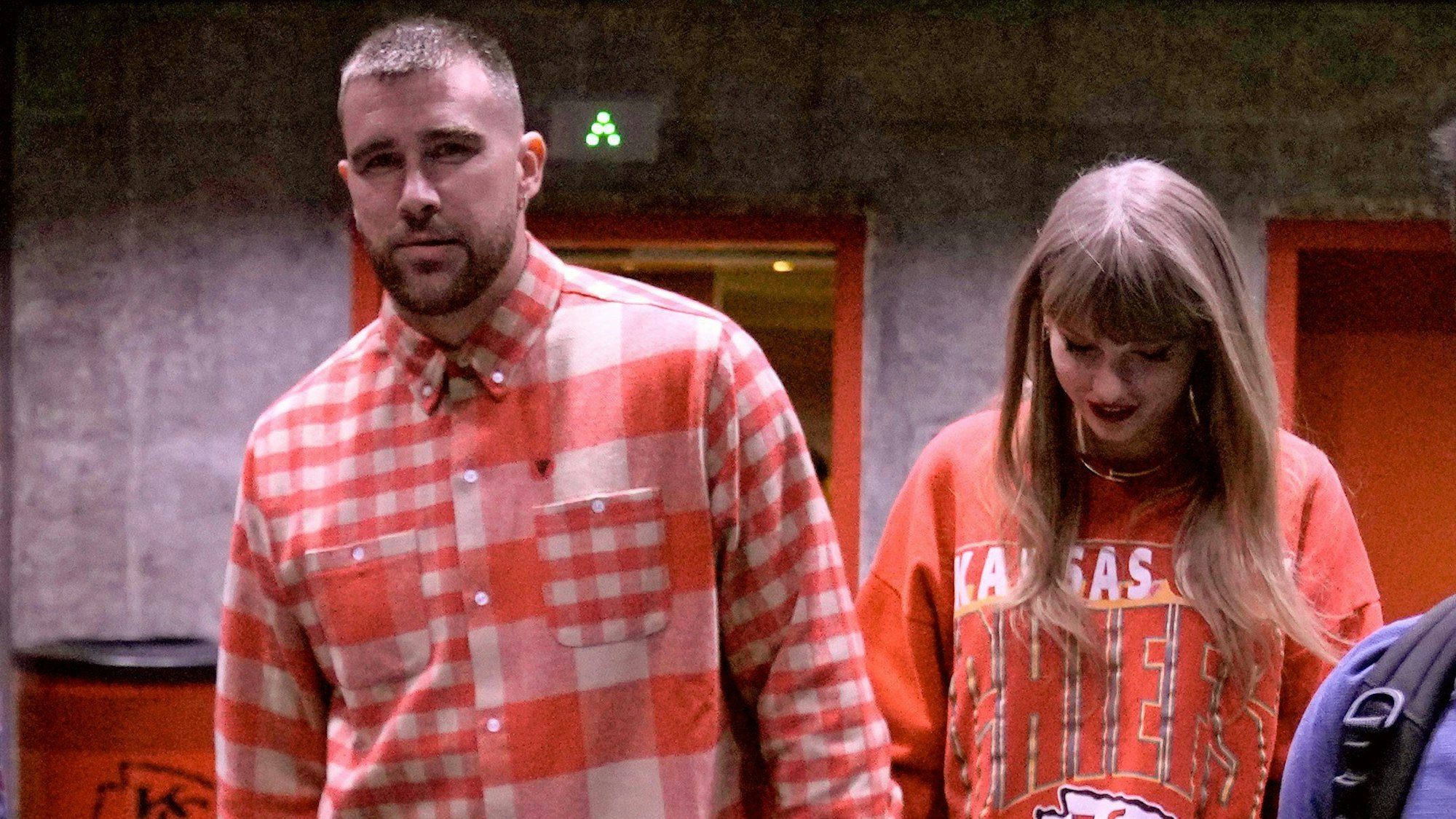 Travis Kelce (l) von Kansas City Chiefs und Sängerin Taylor Swift verlassen Hand in Hand das Stadion nach dem Spiel.