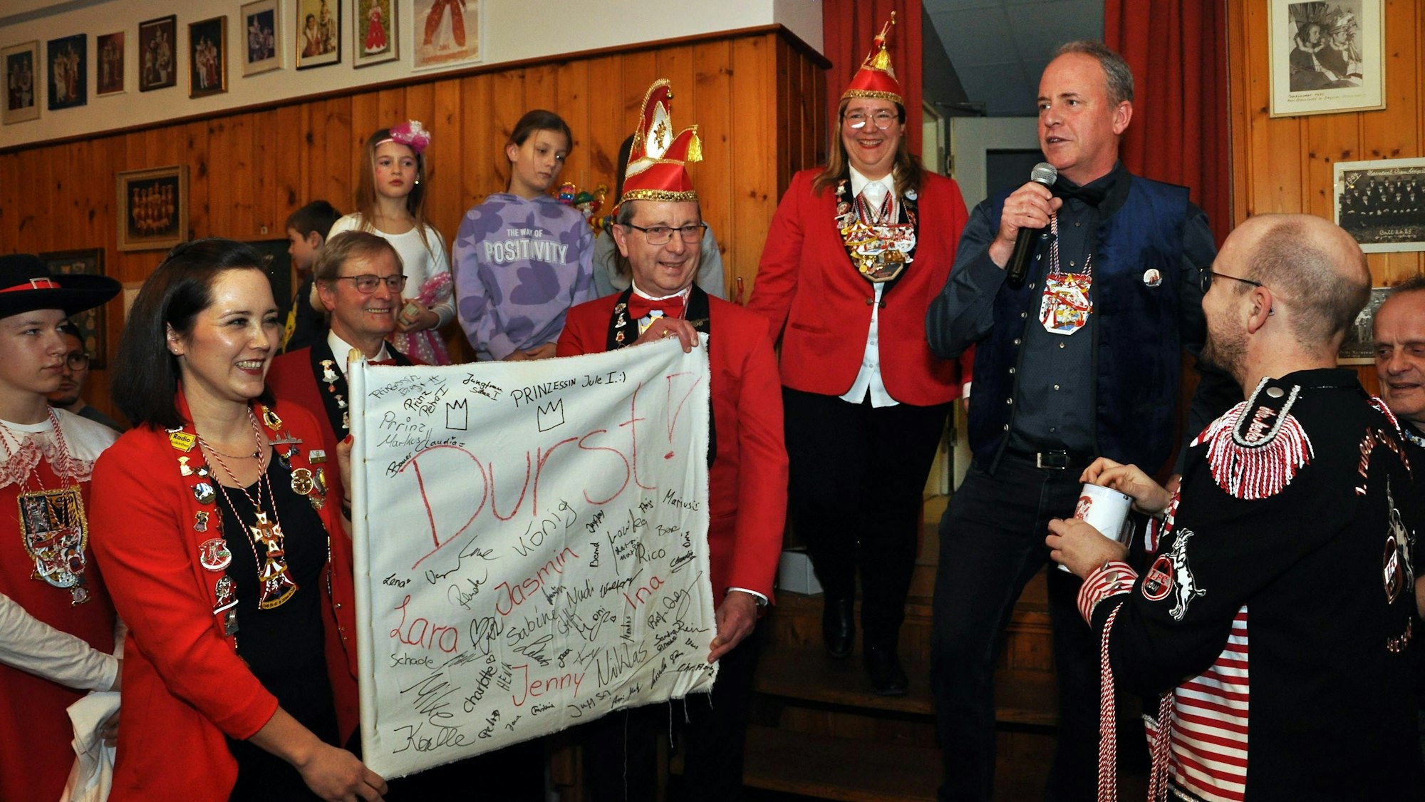 Einige Karnevalisten in roten Jacken halten eine weiße Fahne in der Hand, auf der „Durst!“ steht und auf der zahlreiche Unterschriften sind. Bürgermeister Hermann-Josef Esser hält im Hintergrund eine Rede.