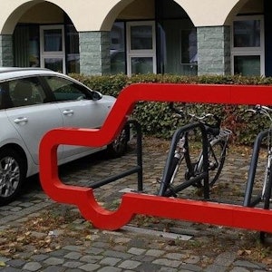 Neben einem Auto parken Fahrräder.