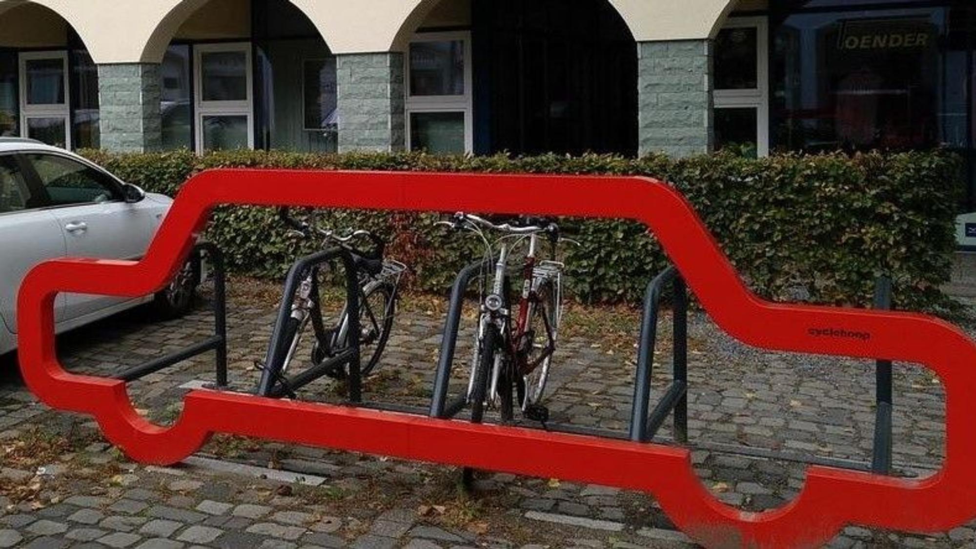 Neben einem Auto parken Fahrräder.