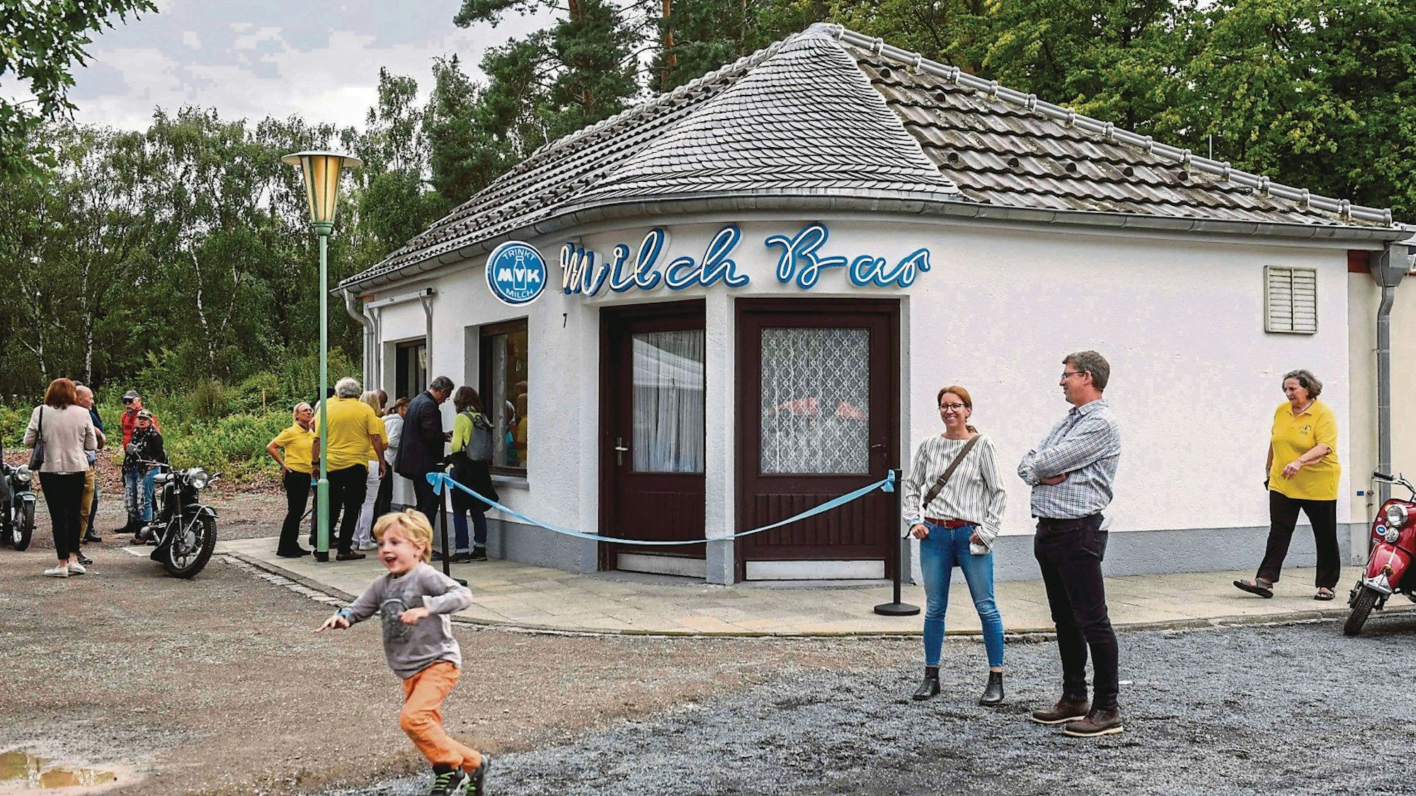 Zu sehen ist ein Gebäude, vor dem Menschen stehen.