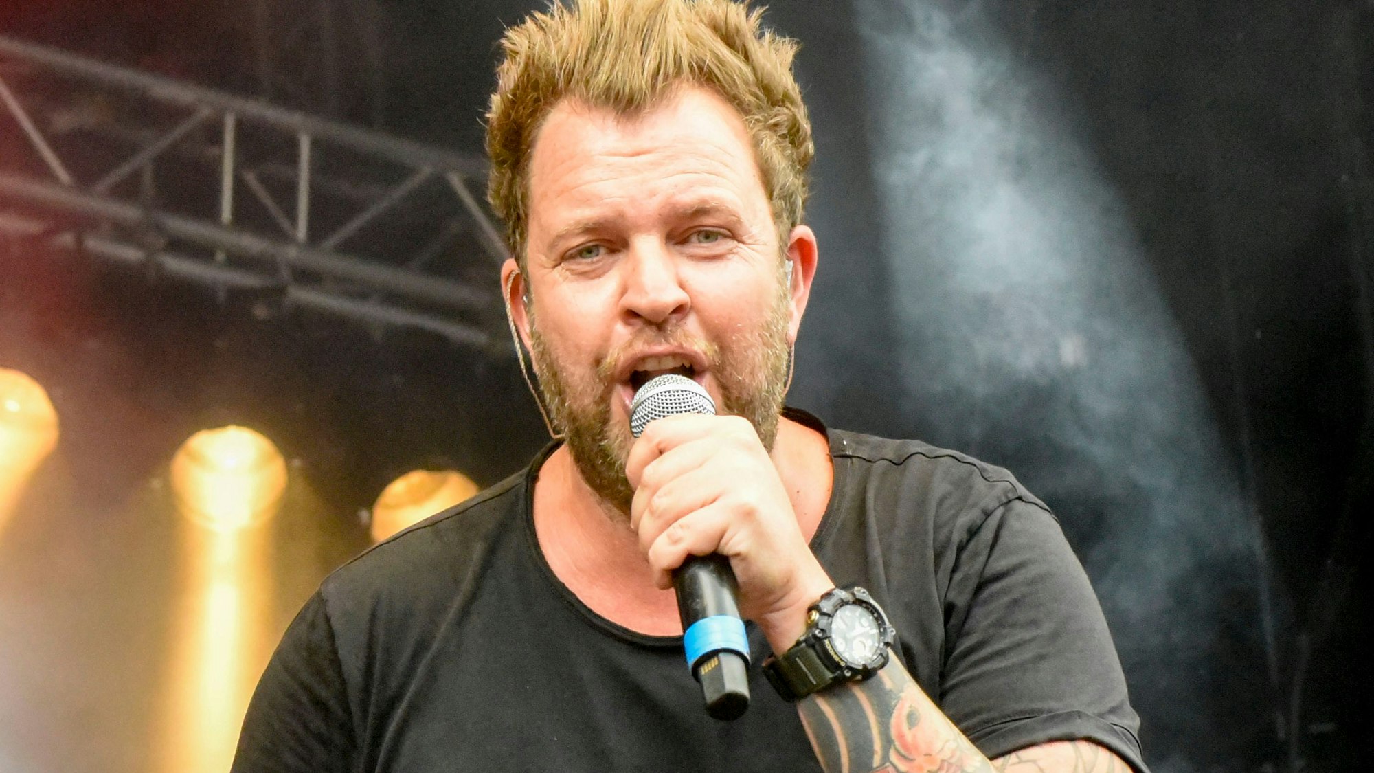 Auf dem Foto ist Paveier-Frontmann Sven Welter bei einem Konzert auf der Bühne zu sehen.