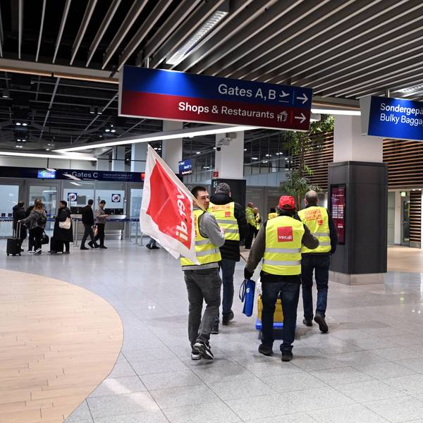 Streikende Flughafenmitarbeiter gehen durch das Terminal.