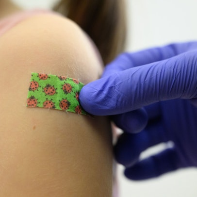 Ein siebenjähriges Mädchen bekommt bei einer Impfaktion der Staatlichen Kunstsammlungen Dresden (SKD) für Kinder und Jugendliche zwischen fünf und 17 Jahren im Residenzschloss nach der Impfung gegen das Coronavirus ein Pflaster auf den Arm geklebt.