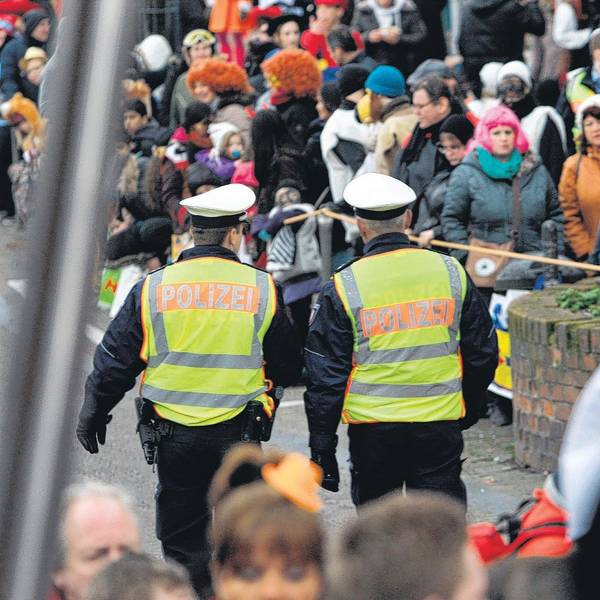 Zwei Polizeibeamte sind im Straßenkarneval unterwegs.