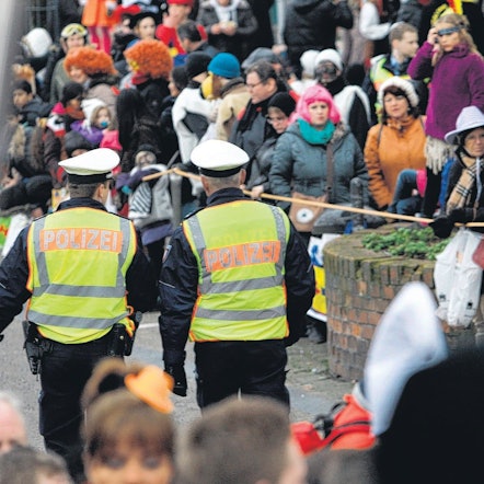 Zwei Polizeibeamte sind im Straßenkarneval unterwegs.