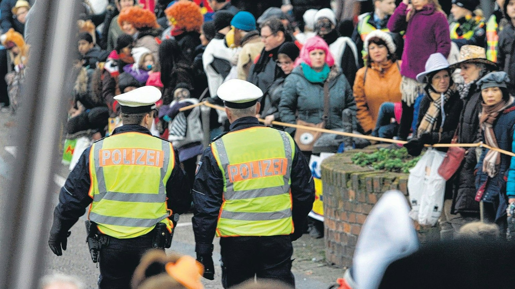 Zwei Polizeibeamte sind im Straßenkarneval unterwegs.
