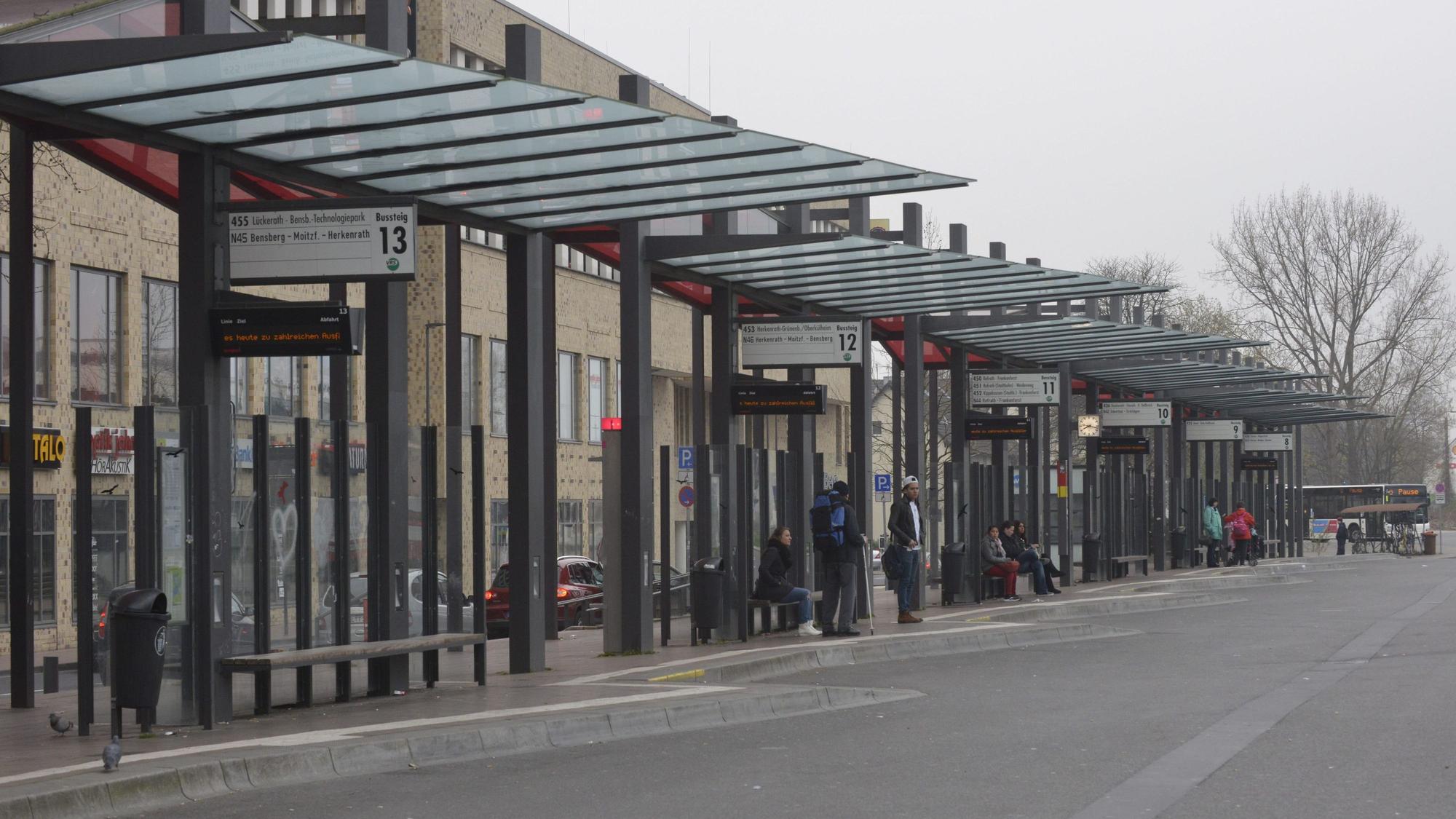 Am Gladbacher Busbahnhof warten einige Fahrgäste, im Hintergrund ist lediglich ein Bus zu sehen.