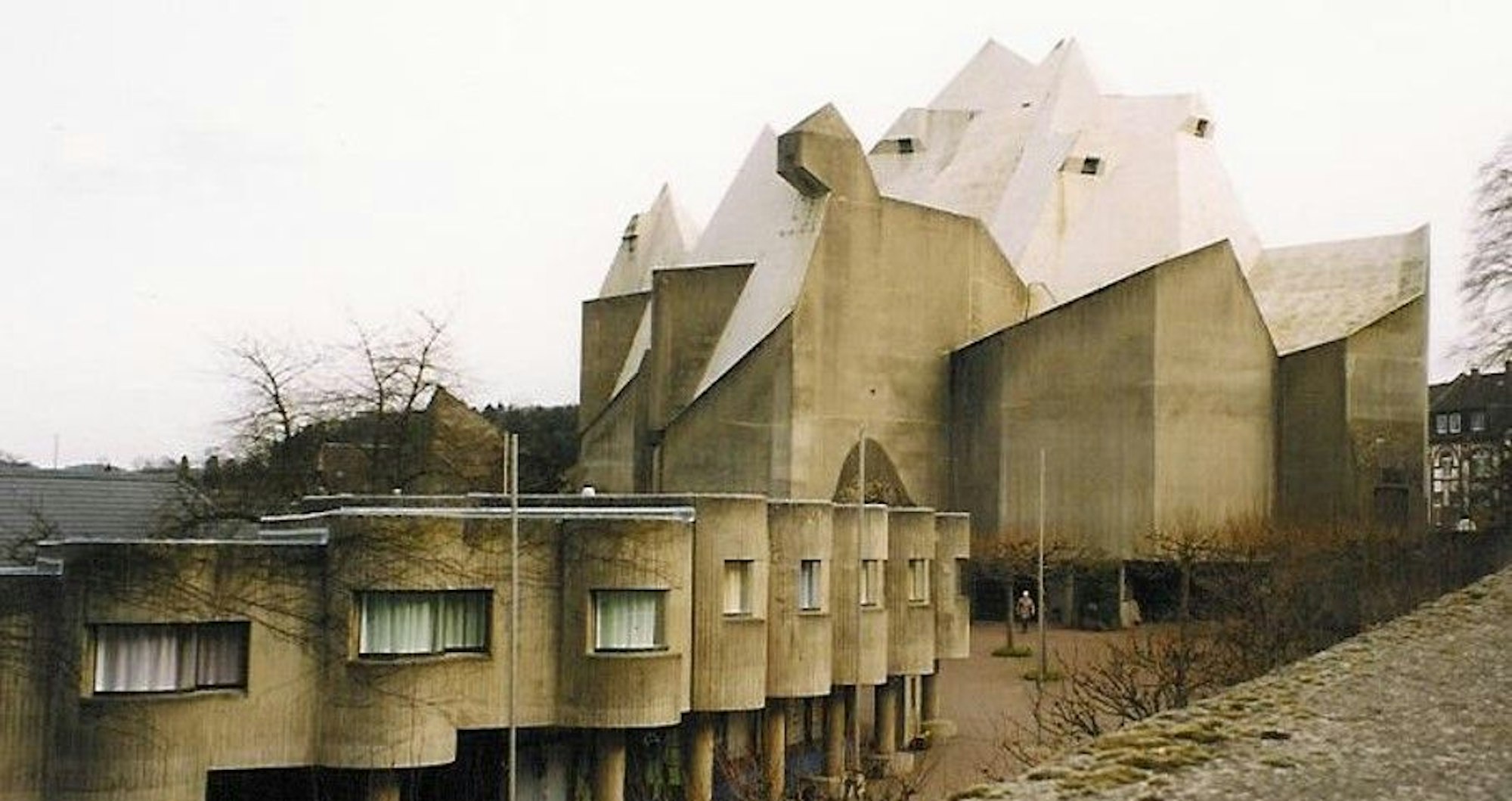 Wohnhäuser mit halbrunden Fassaden und eine Kirche aus Beton
