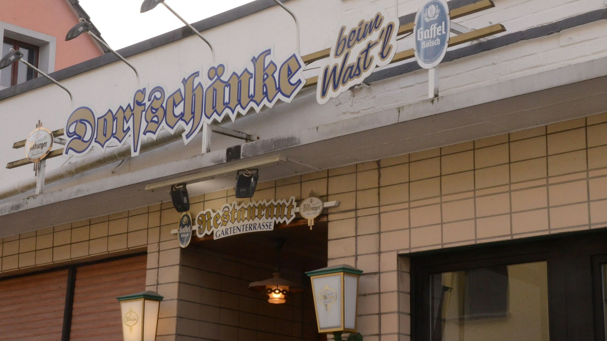 Die Lichtreklame für eine Gaststätte „Die Dorfschänke beim Wast'l“ steht darauf.