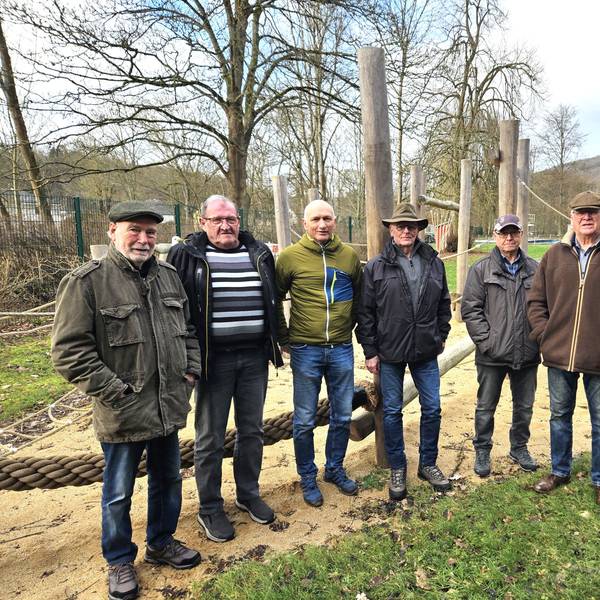 Sechs Männer, die „Rentner von Gemünd“, stehen auf einem Spielplatz.