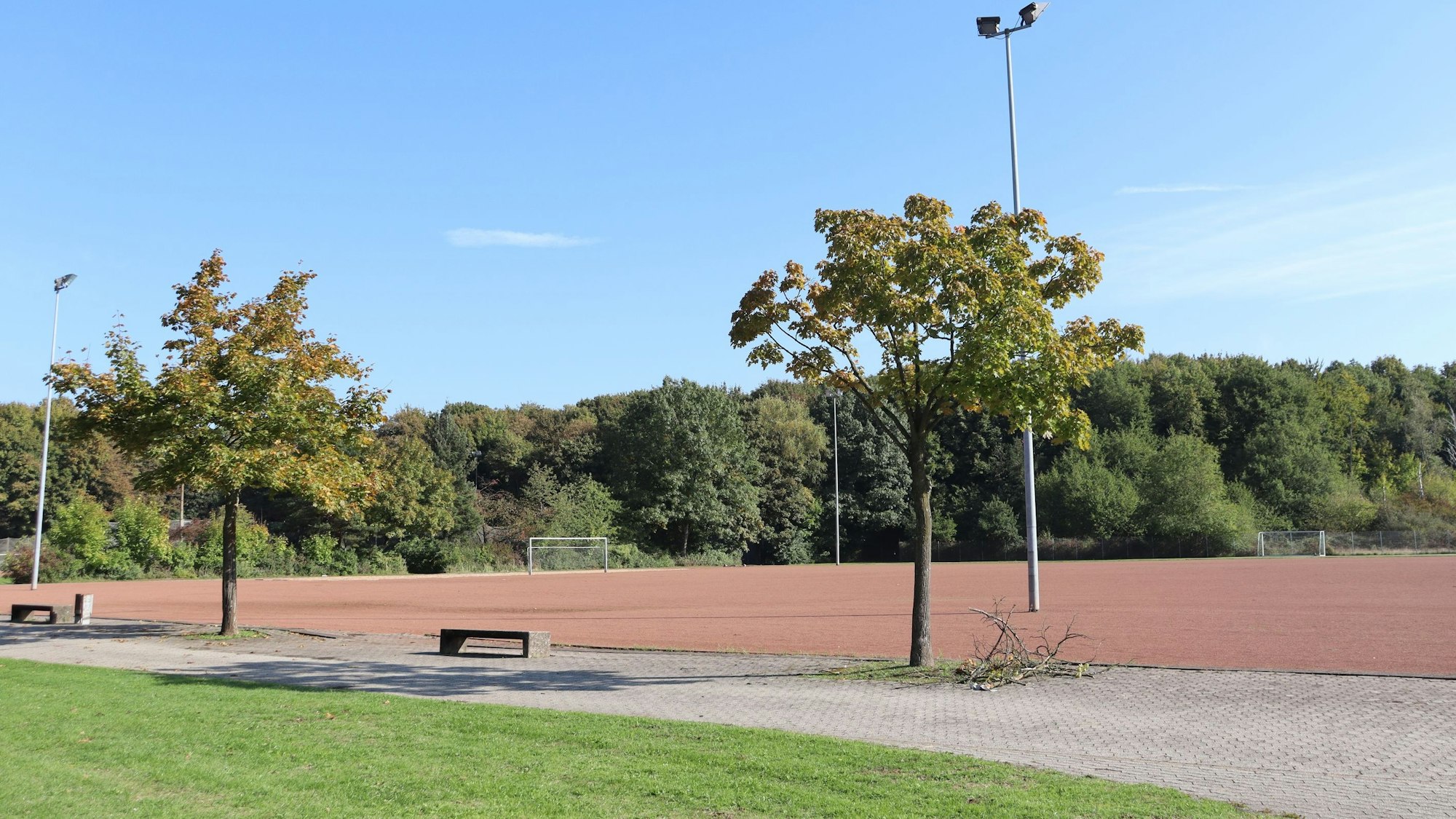 Blick auf einen großen Aschenplatz mit Bäumen im Hintergrund