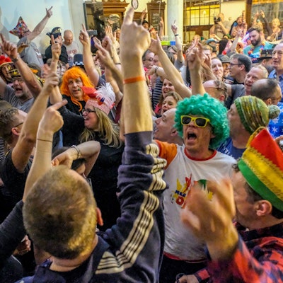 Verkleidete und unverkleidete Menschen feiern miteinander.