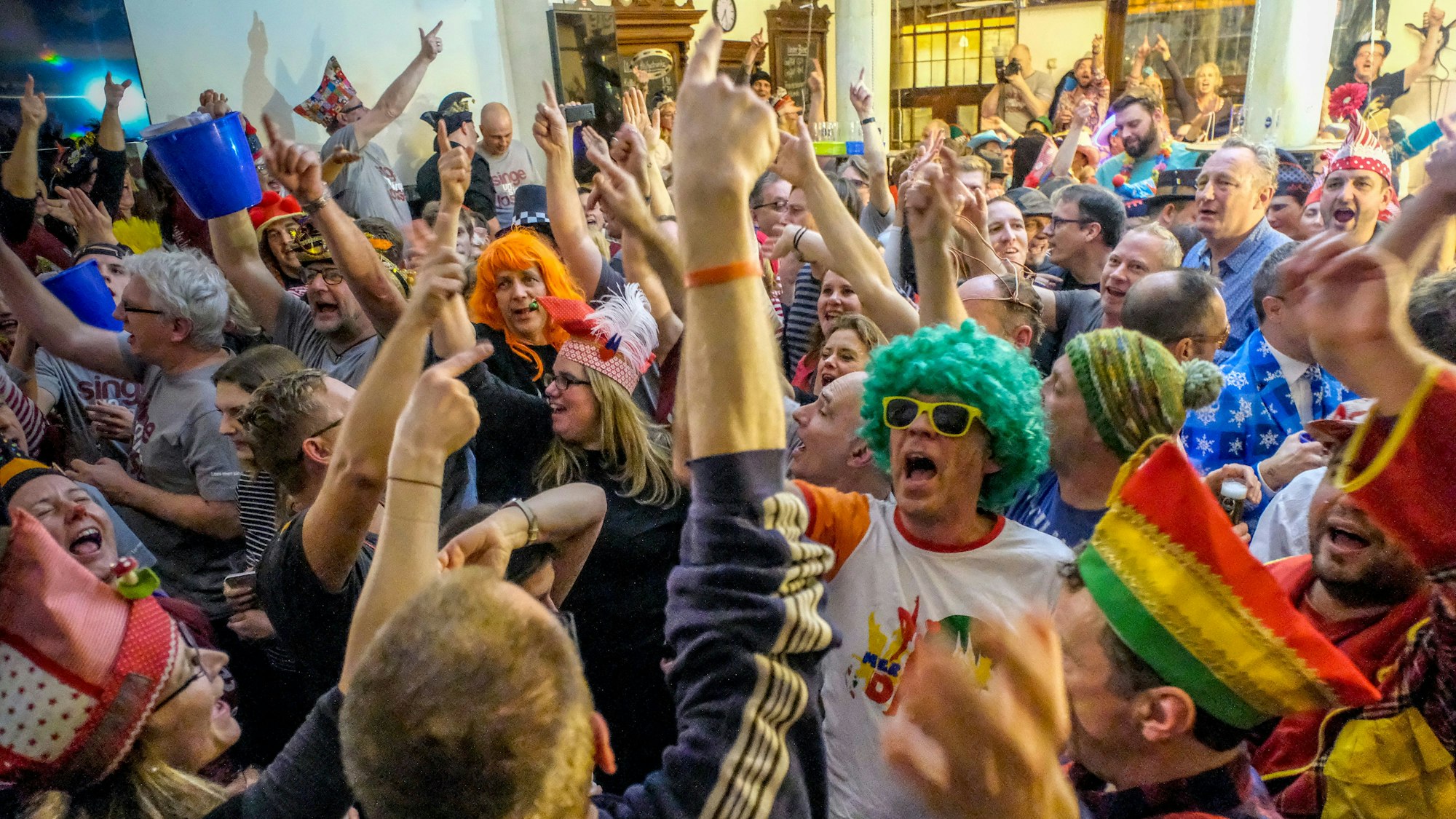 Verkleidete und unverkleidete Menschen feiern miteinander.