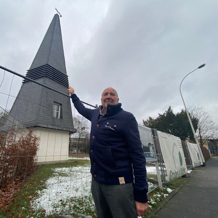 Zu sehen ist Alfred Fassbender vor dem Glockenturm der abgebrochenen Johanneskirche.
