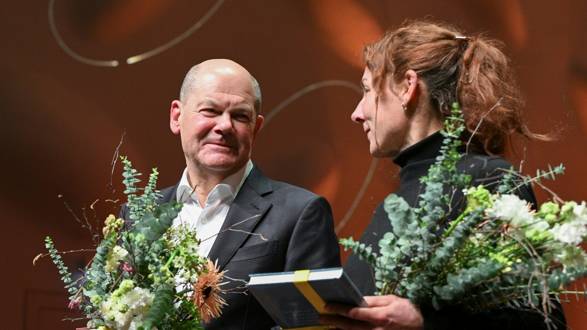 30.01.2024, Brandenburg, Potsdam: Bundeskanzler Olaf Scholz (SPD) und die Autorin Juli Zeh stehen nach einem Gespräch zum Thema ·In Zeiten des Umbruchs· auf der Bühne im Nikolaisaal. Foto: Jens Kalaene/dpa +++ dpa-Bildfunk +++