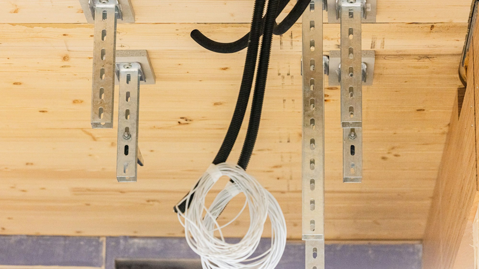 Kabel hängen aus einer Holzdecke.