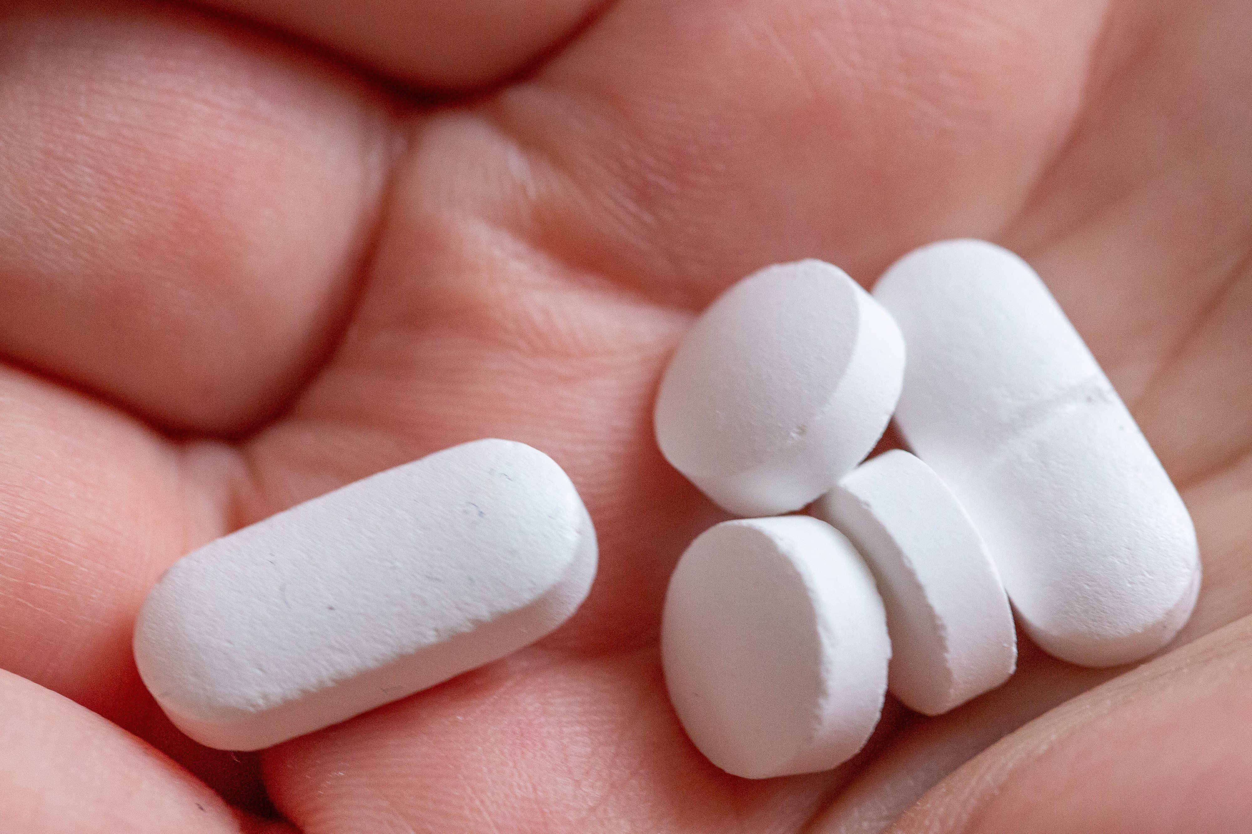 10.02.2022, Berlin: Eine Person hält Tabletten und Vitaminpräparate von Calcium, Vitamin D und Magnesium in der Hand. Viele Leute nehmen Tabletten mit Vitaminen und Mineralstoffen. Doch das ist oft unnötig.