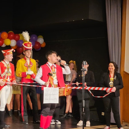 Das Bild zeigt Küfer Ricardo, während er sein Motto auf der Bühne vorträgt. Er ist umrahmt von Flatterband.