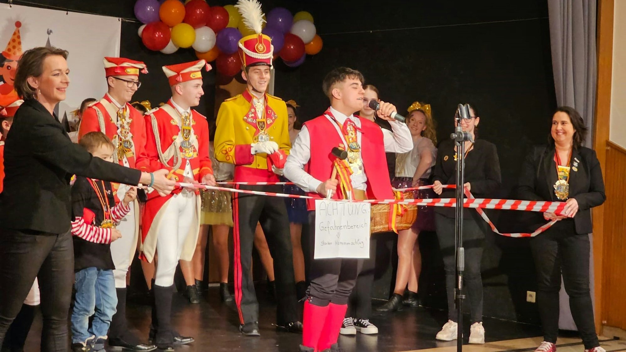 Das Bild zeigt Küfer Ricardo, während er sein Motto auf der Bühne vorträgt. Er ist umrahmt von Flatterband.