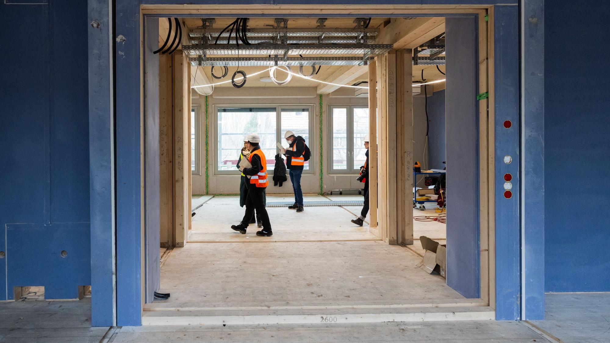 Menschen stehen auf einer Baustelle.