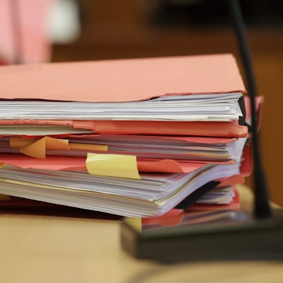 Gerichtsakten der Verteidiger liegen auf einem  Tisch im Gerichtsaal.