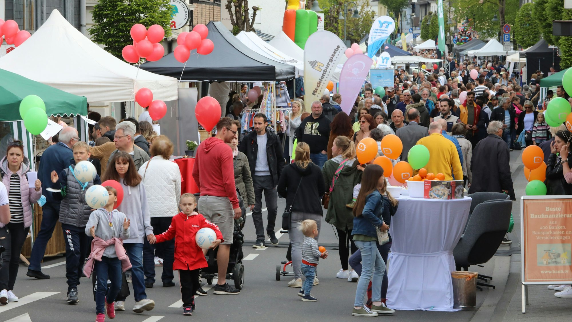 Menschen gehen über die Festmeile der gesperrten Hauptstraße in Overath beim Overather Frühling 2022.