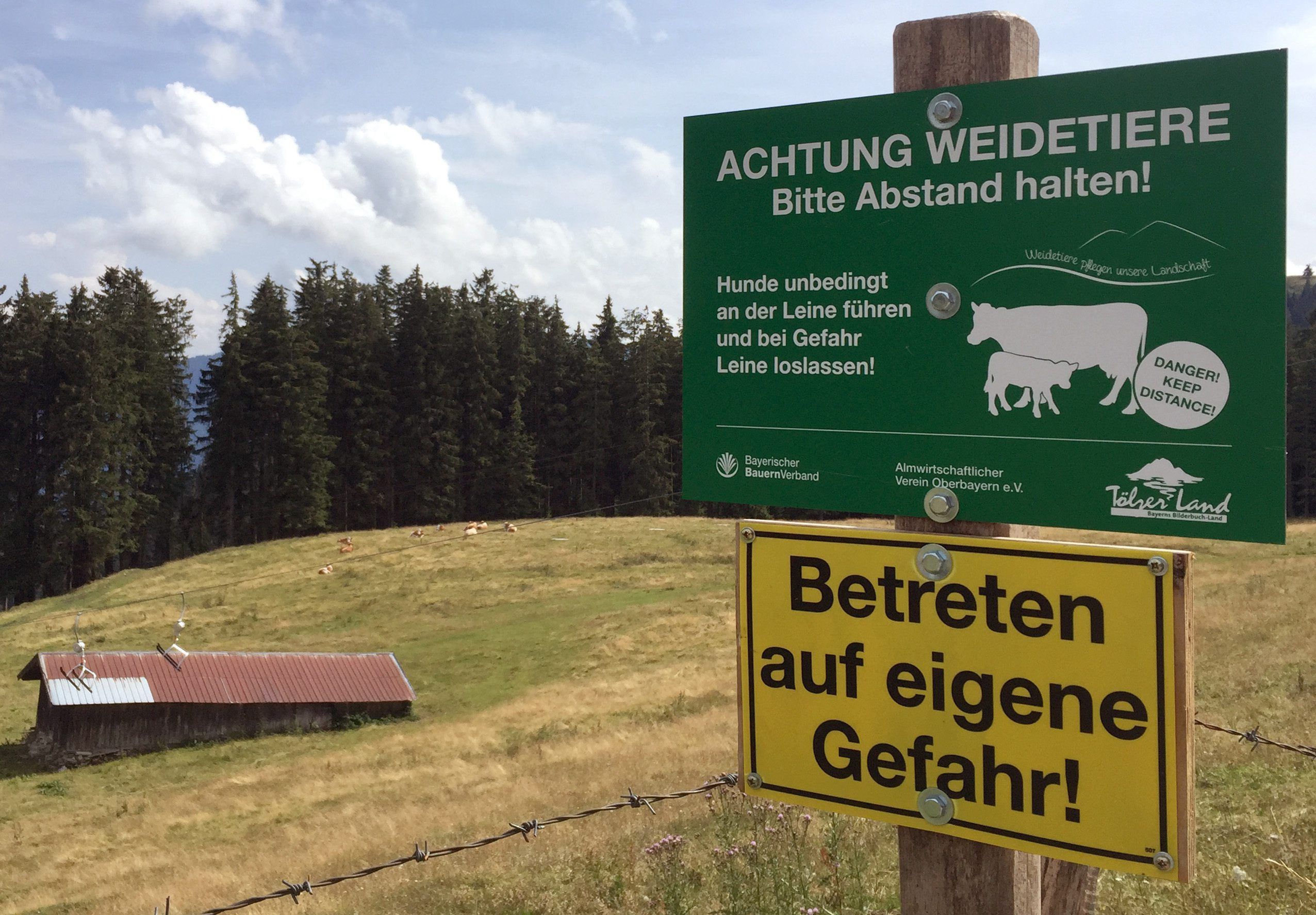 ARCHIV - 31.07.2019, Bayern, Wackersberg: Ein Schild auf dem Blomberg warnt vor dem Betreten einer Kuhweide.  (zu dpa: «Nach tödlicher Kuh-Attacke: Landwirt muss nicht zahlen») Foto: Sabine Dobel/dpa +++ dpa-Bildfunk +++