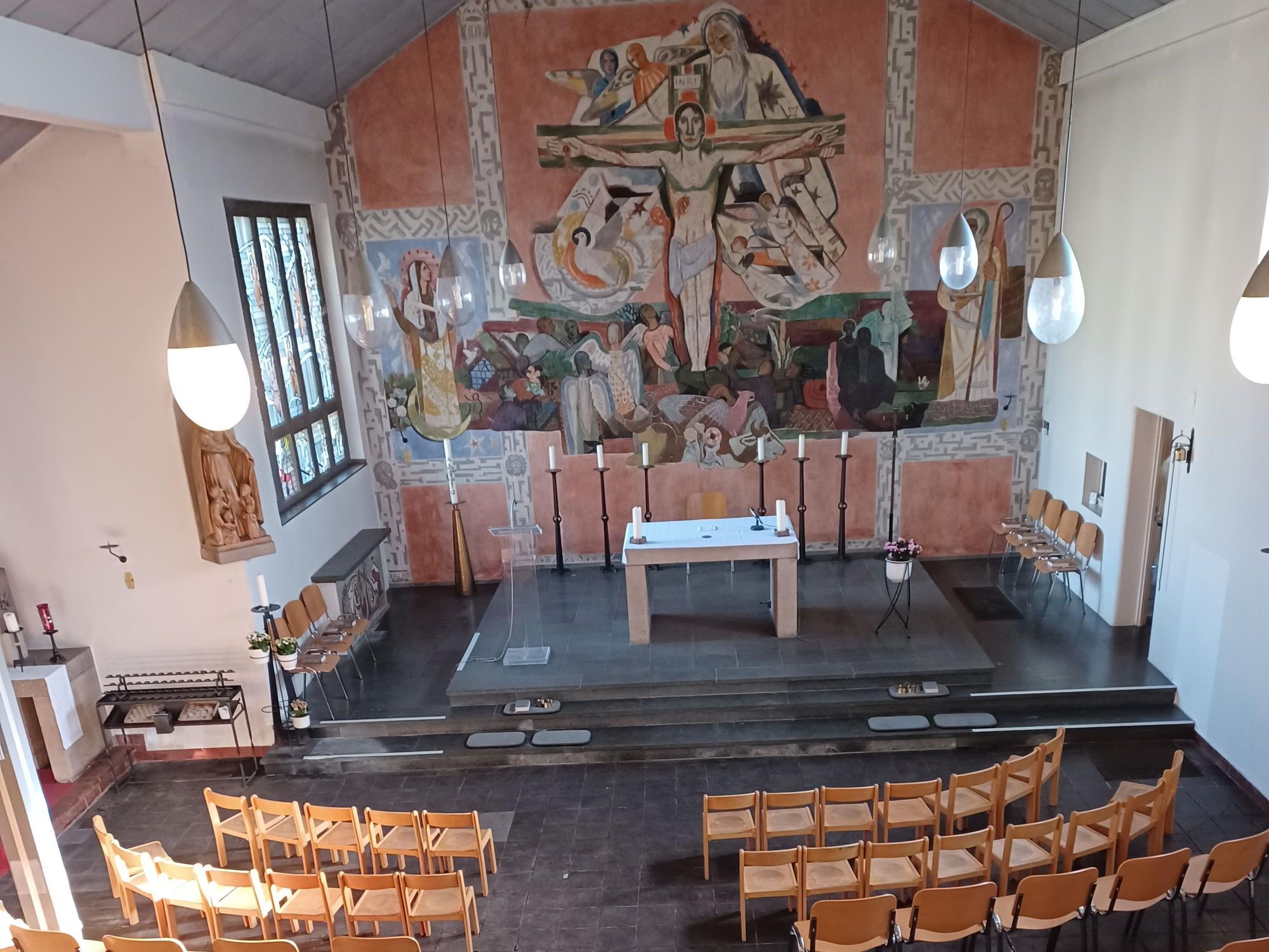 Der Innenraum der Kirche: Im Vordergrund stehen Stühle, im Hintergrund ist der Altar zu sehen.