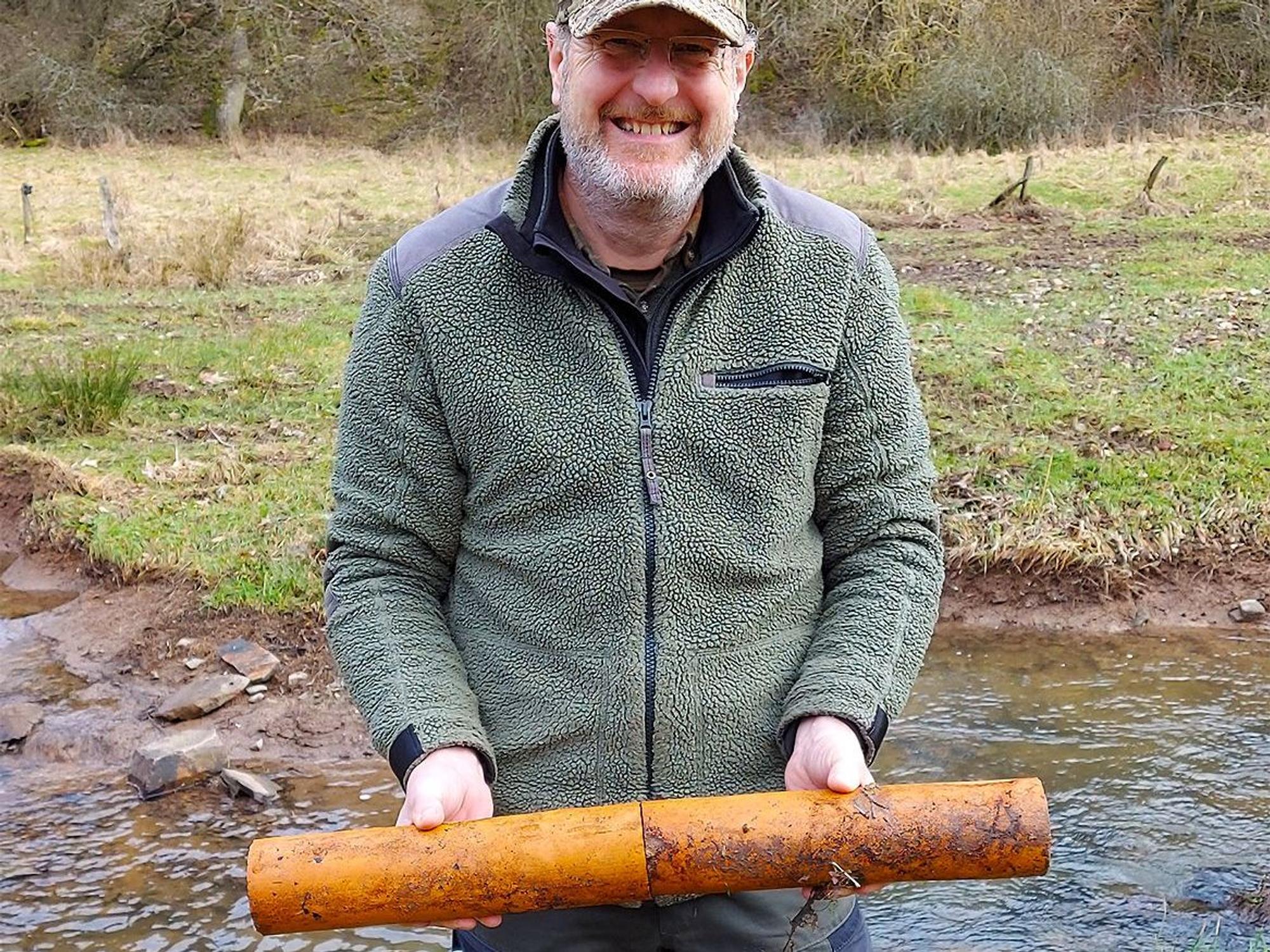 Jens Gelderblom zeigt zwei Teilstücke der alten Tondrainagen.