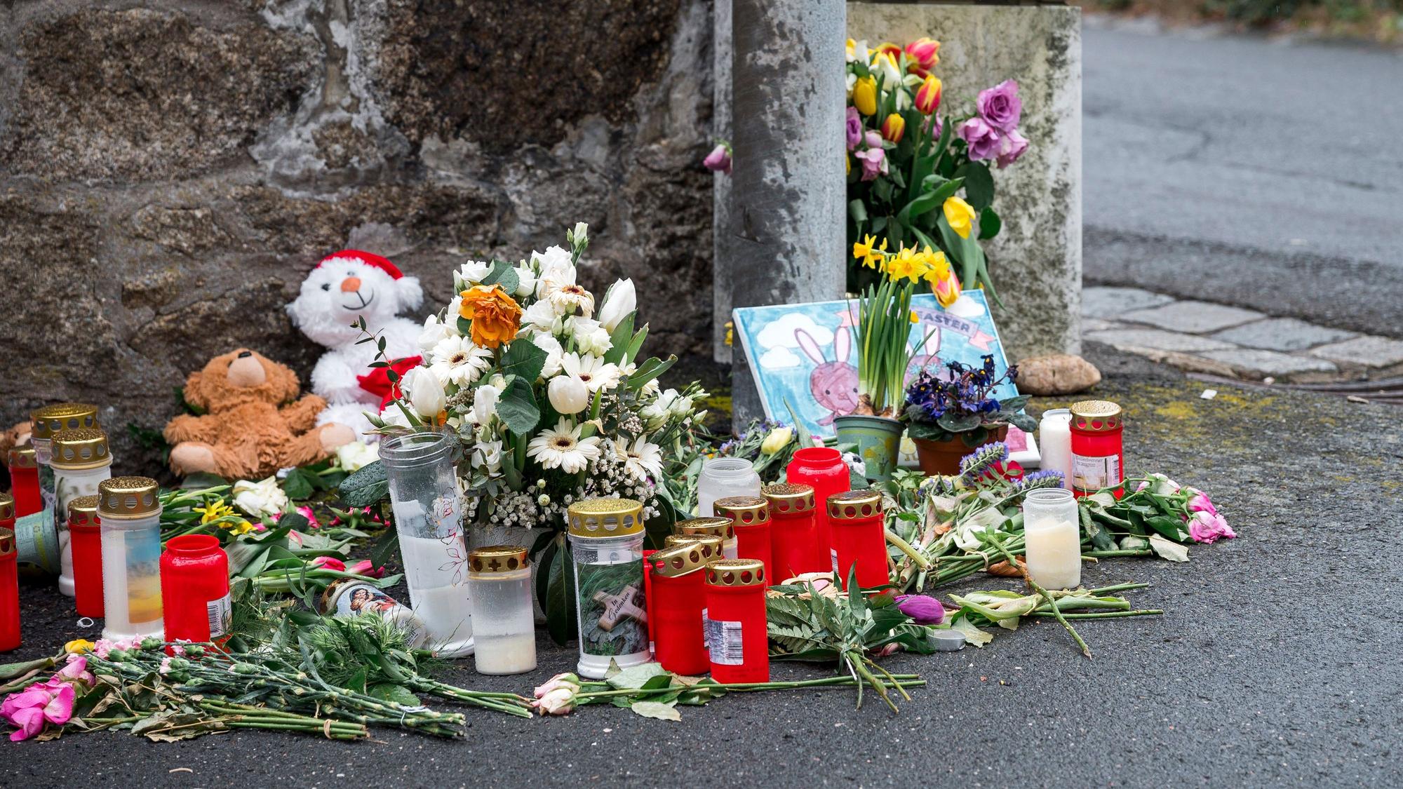 ARCHIV - 12.04.2023, Bayern, Wunsiedel: An einer Mauer vor dem Kinder- und Jugendhilfezentrum, in dem eine Zehnjährige tot aufgefunden wurde, liegen Blumen, Kuscheltiere und Kerzen. (zu dpa: «Welche bedeutenden Verfahren 2024 an Bayerns Gerichten anstehen») Foto: Daniel Vogl/dpa +++ dpa-Bildfunk +++