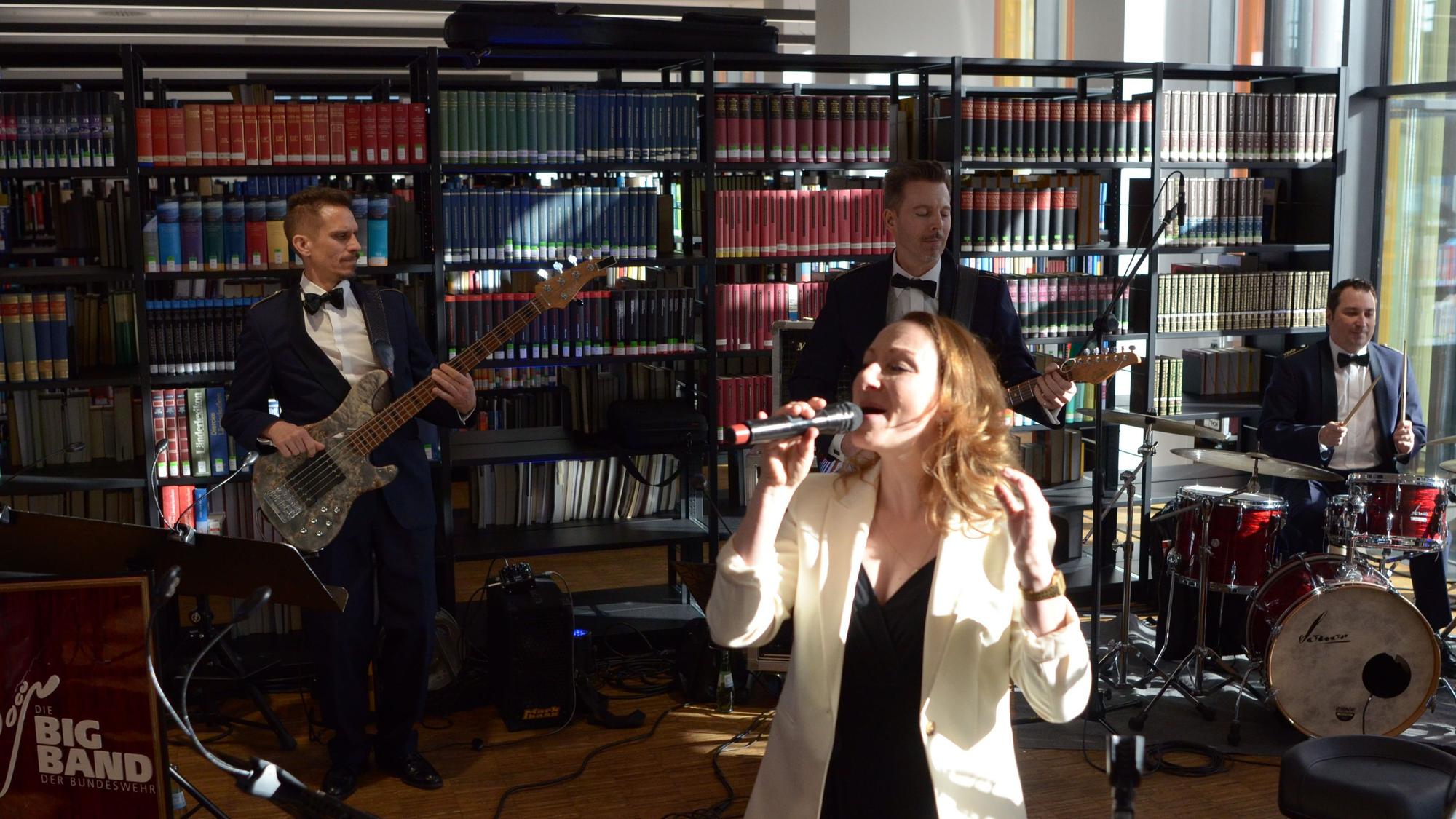 Inga Lüning singt in ein Mikrofon, hinter ihr drei Musiker an Bass, Gitarre und Schlagzeug.