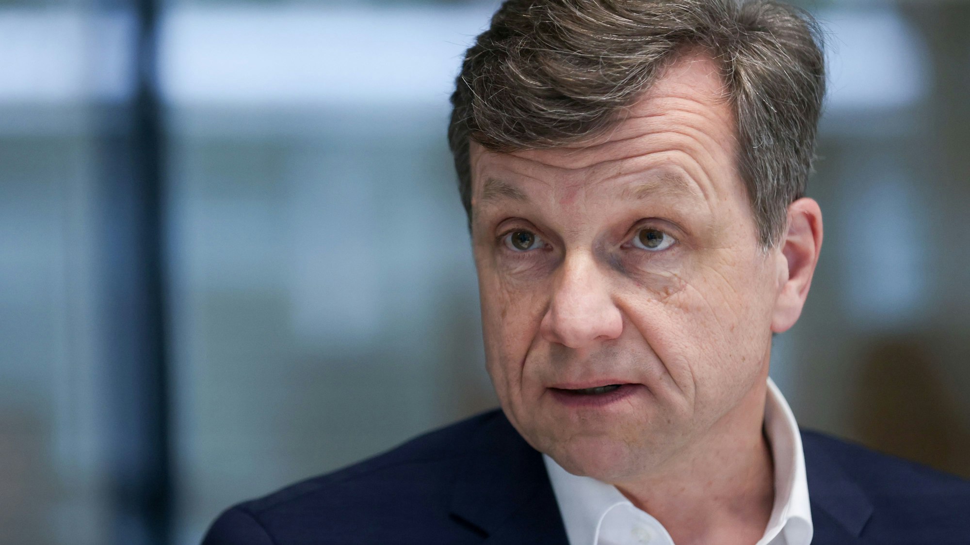 Halbporträt eines mittelalten Mannes im Anzug mit braunem Haar und Seitenscheitel